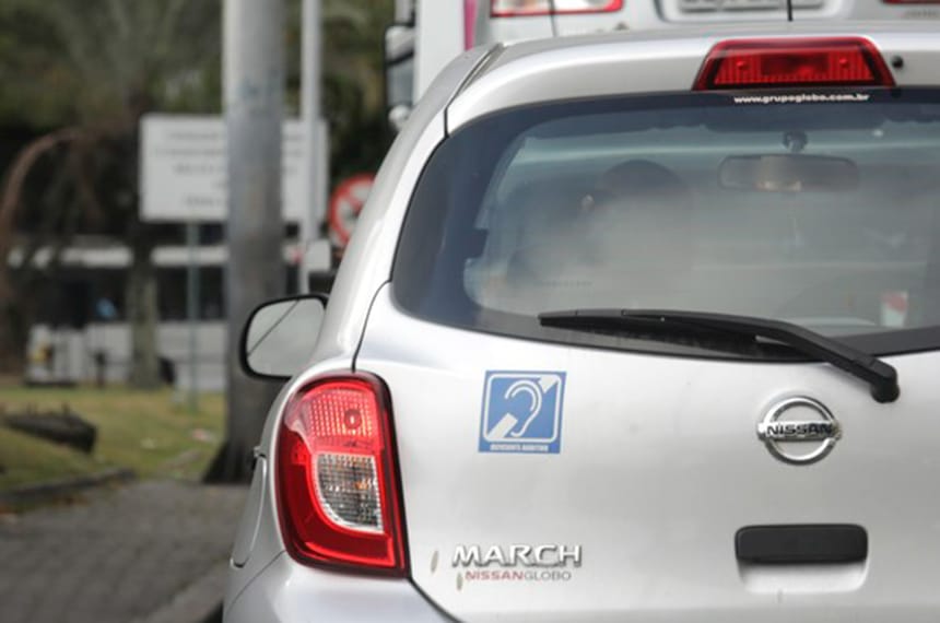 Um carro com adesivo indicativo de surdez.