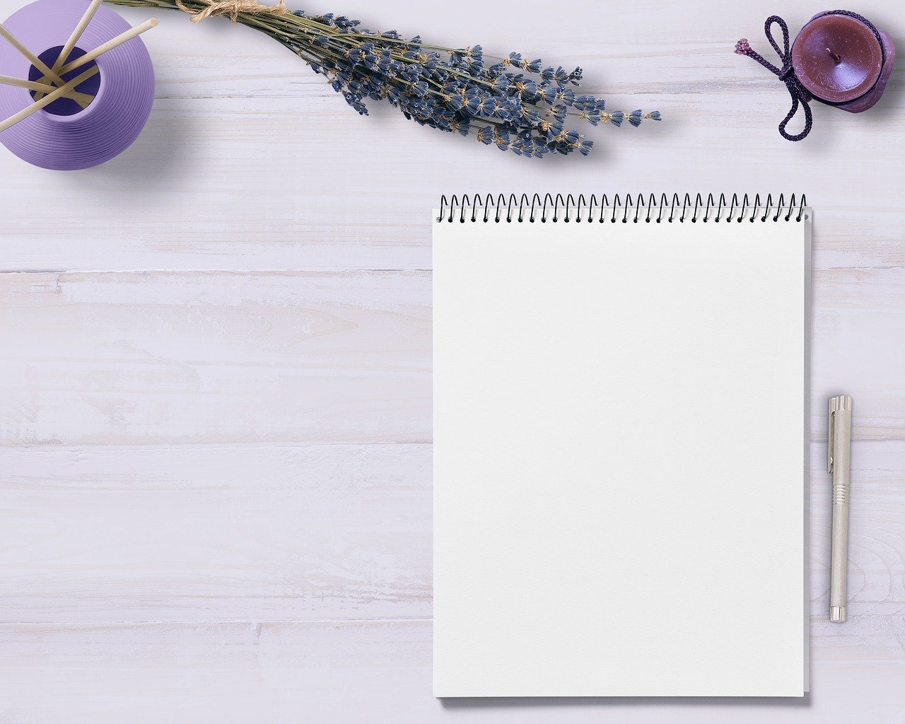 Um caderno e uma caneta indicam produção textual