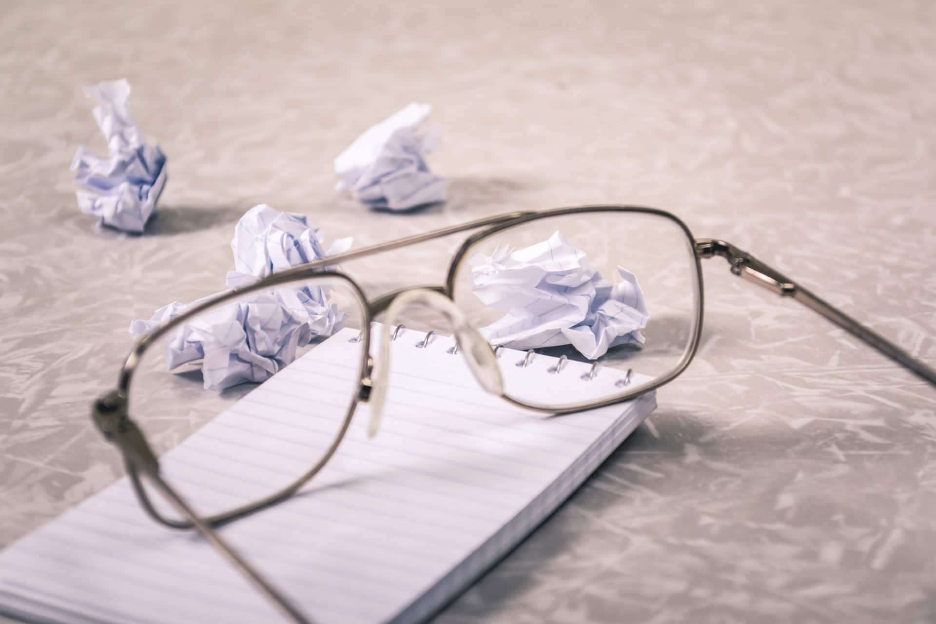 óculos sobre caderno de folhas em branco