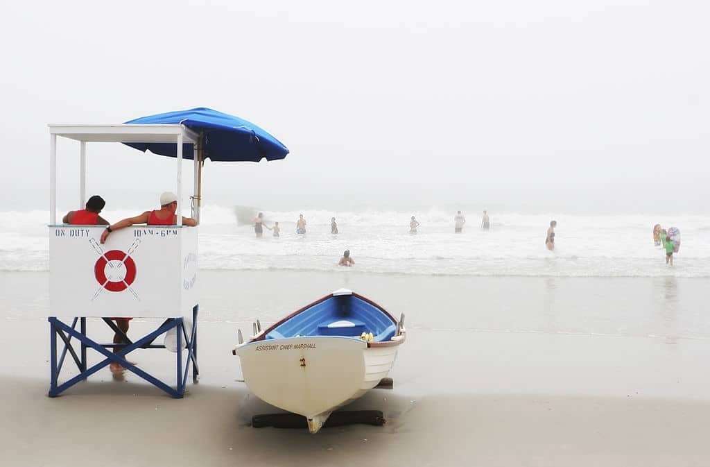 Imagem de salva-vidas mantendo vigilância na praia.