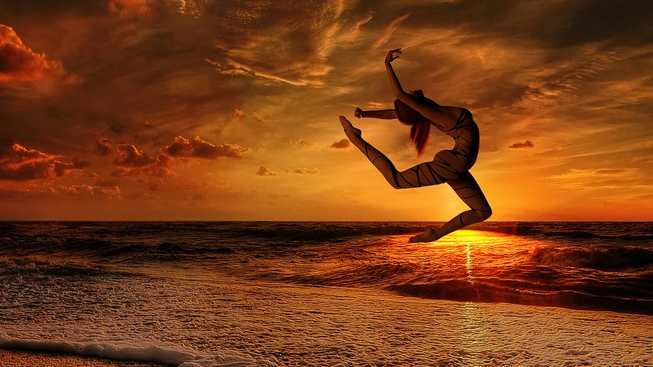 Uma mulher fazendo salto de dança na praia