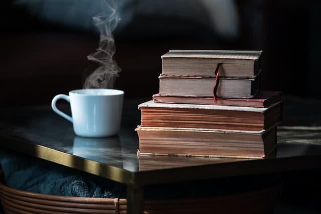 Pilha de livros com xícara de café