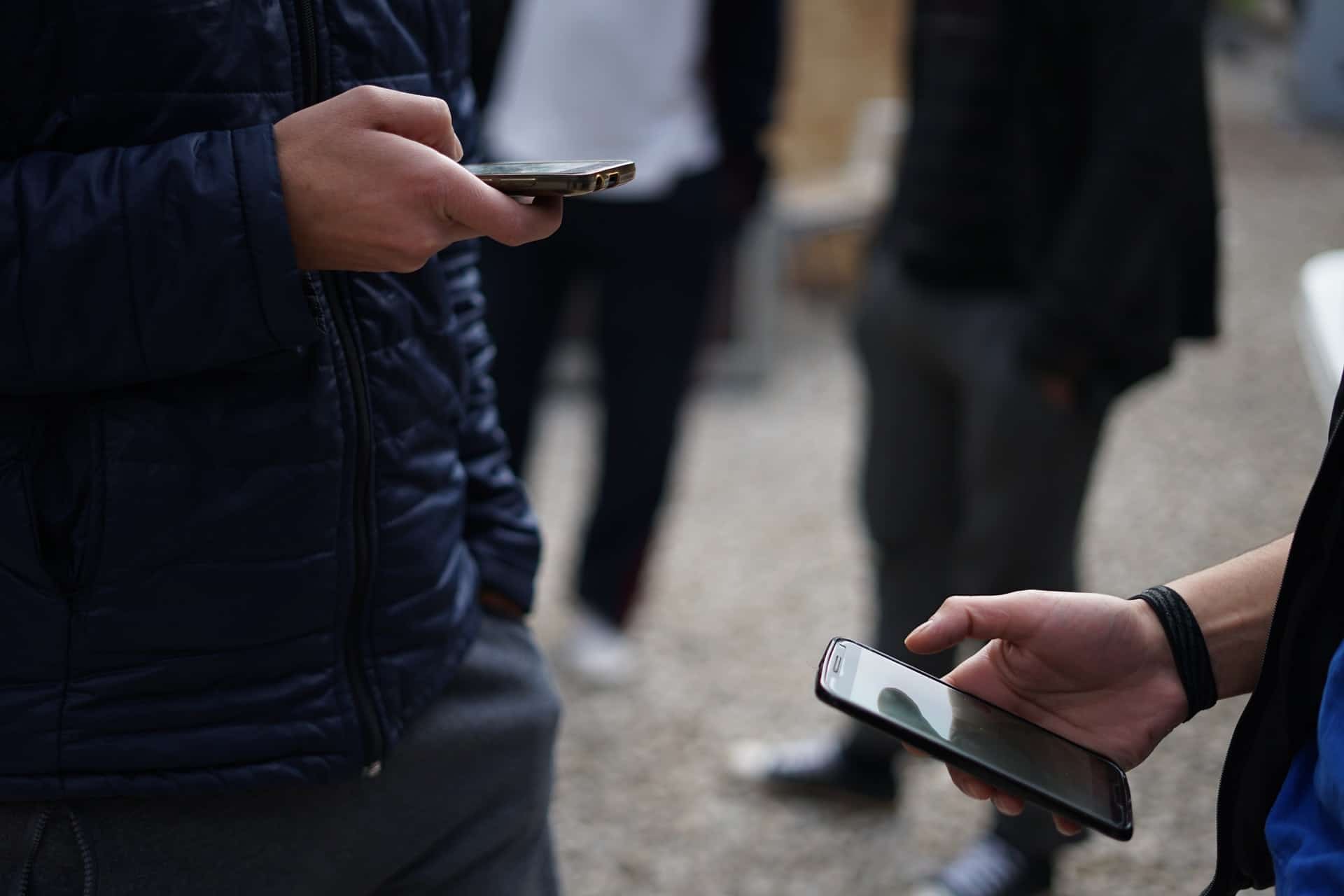 Pessoas utilizando o celular ao ar livre,