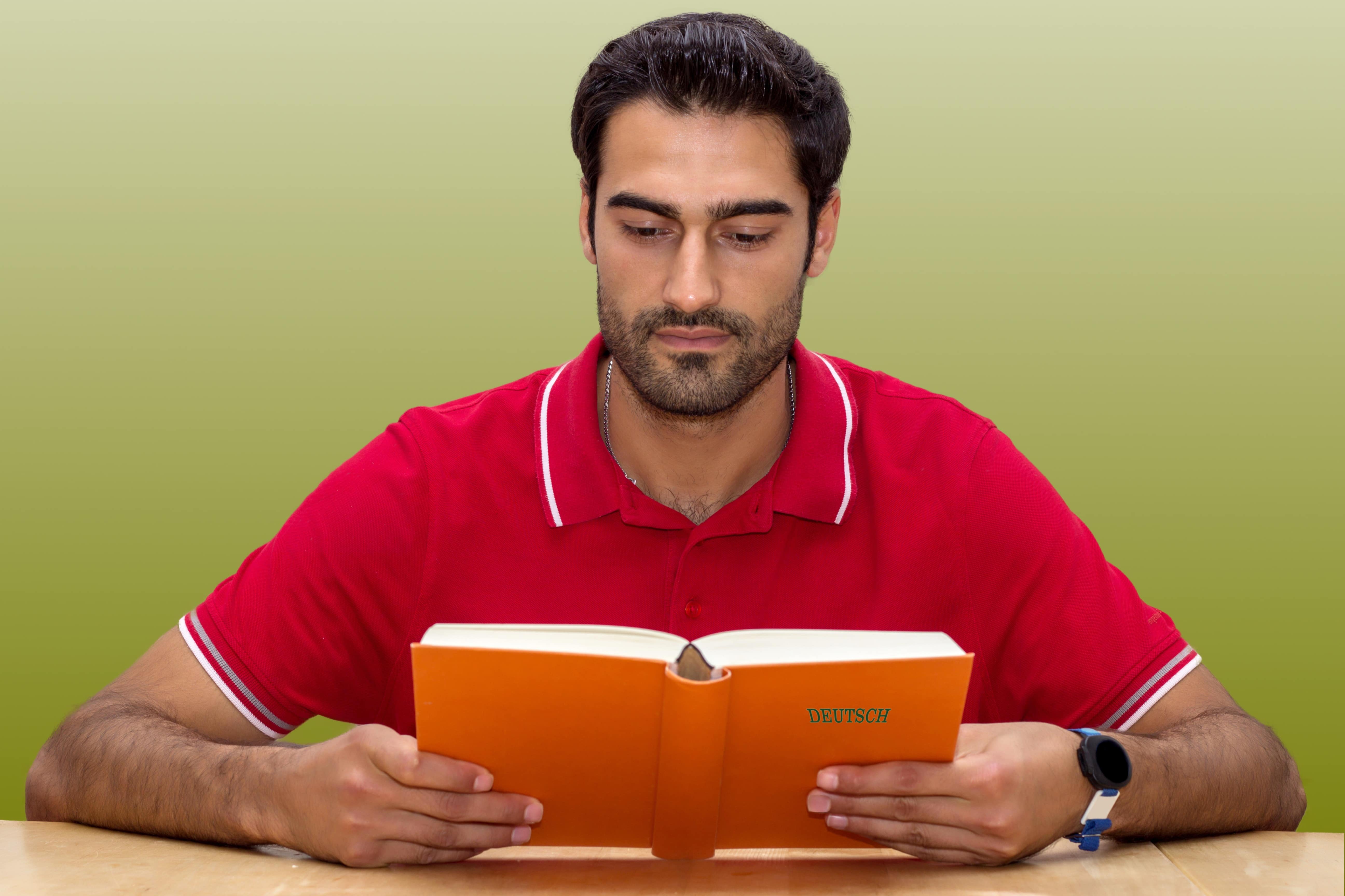 Estudante lendo livro em alemão.