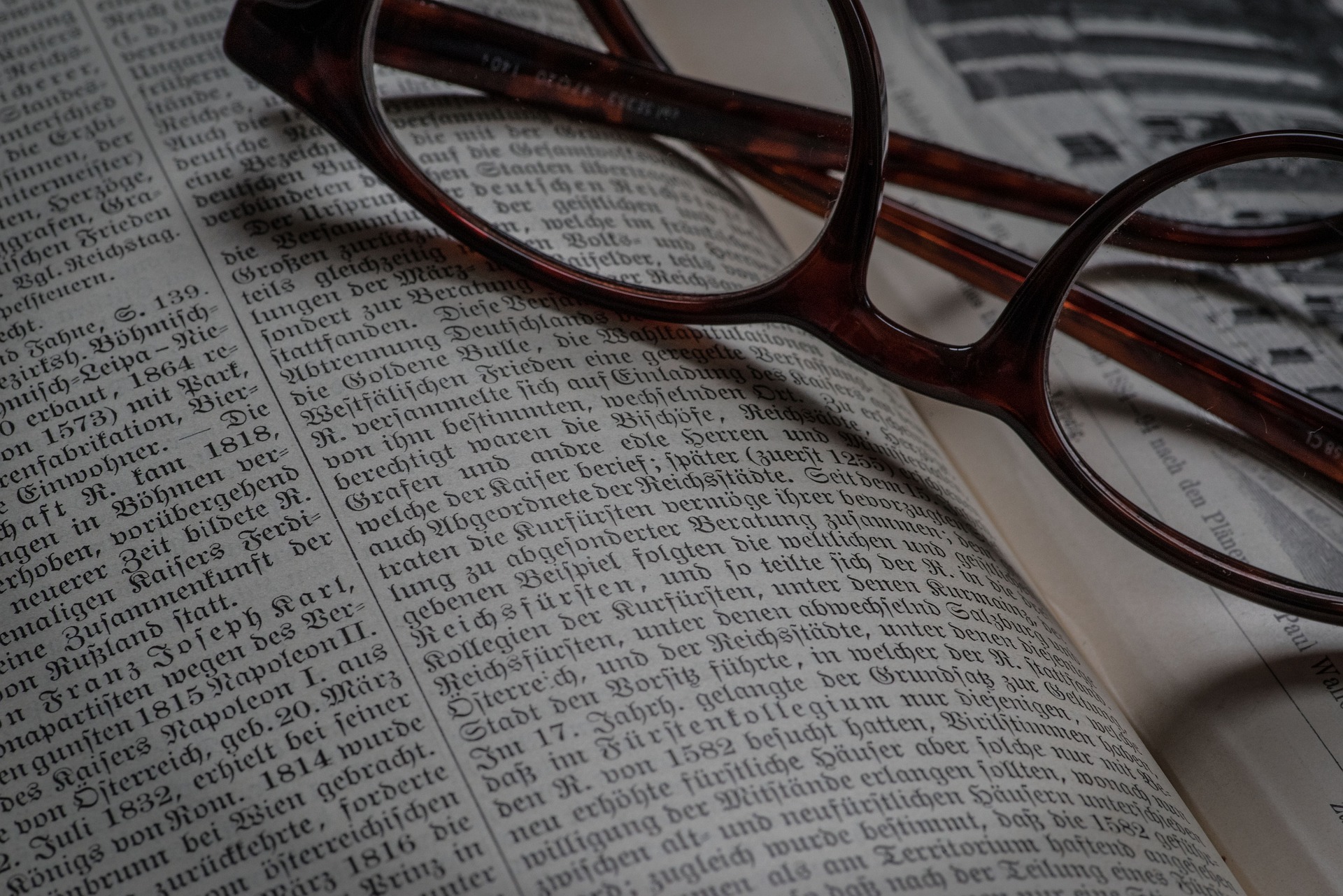 Óculos em cima do livro alemão.