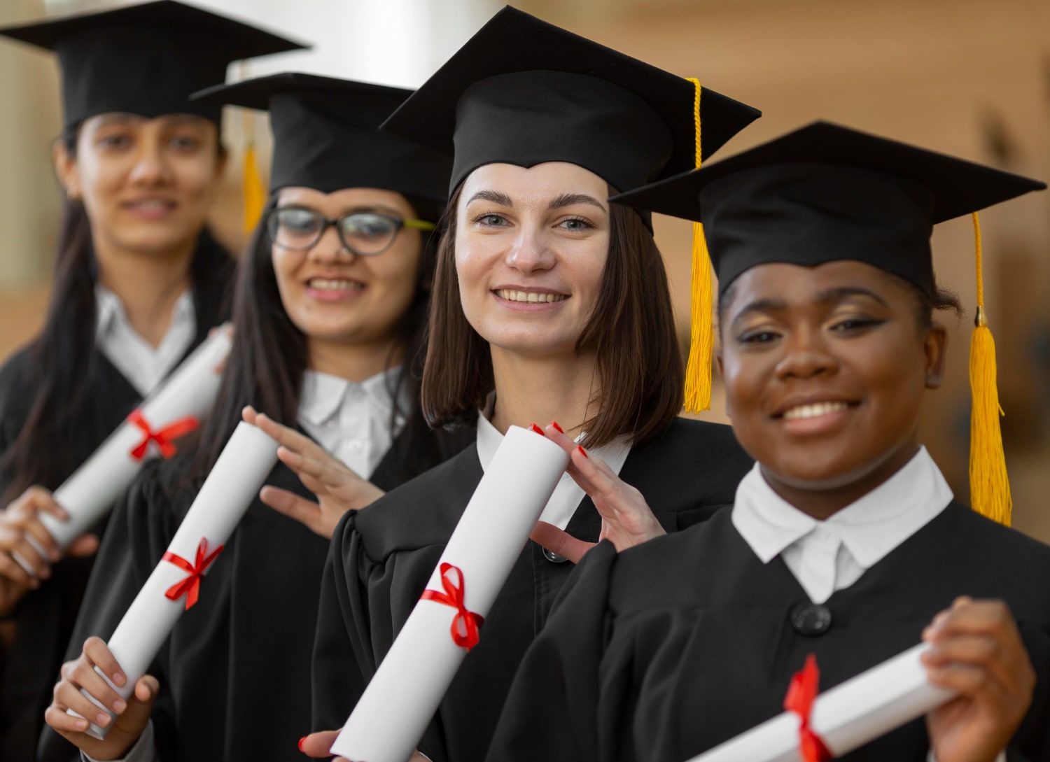Alunos formados, segurando diploma e vestindo beca.