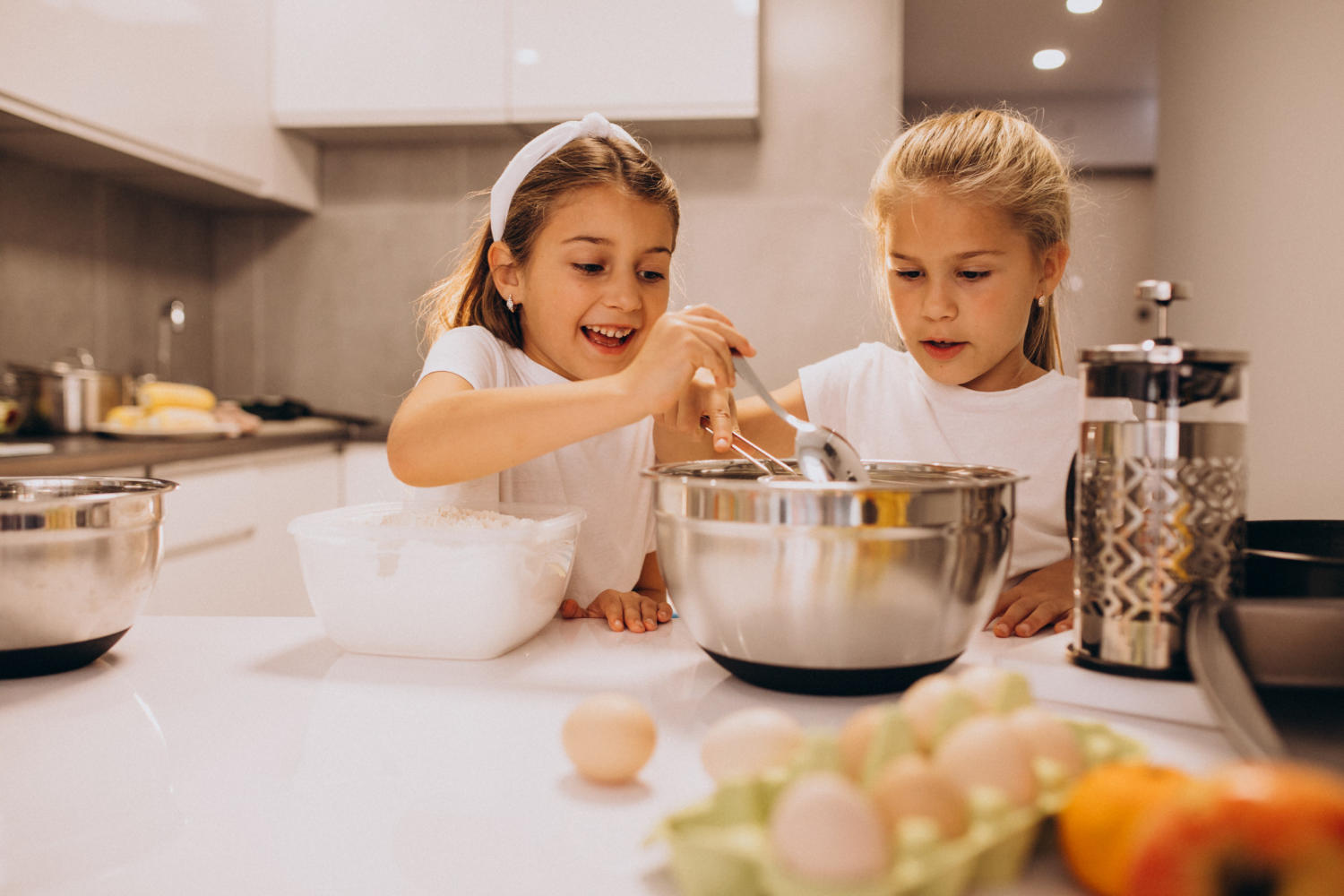 Duas crianças ajudando na cozinha.