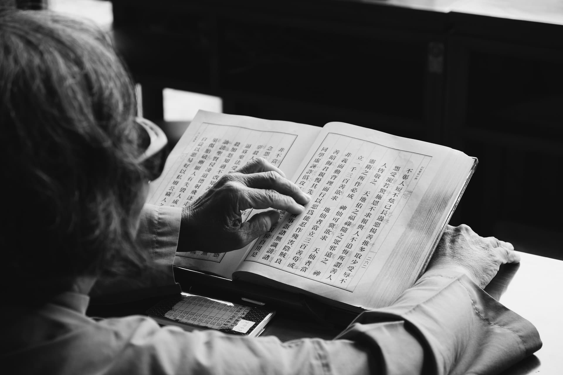 Mulher estudando chinês pelo livro.