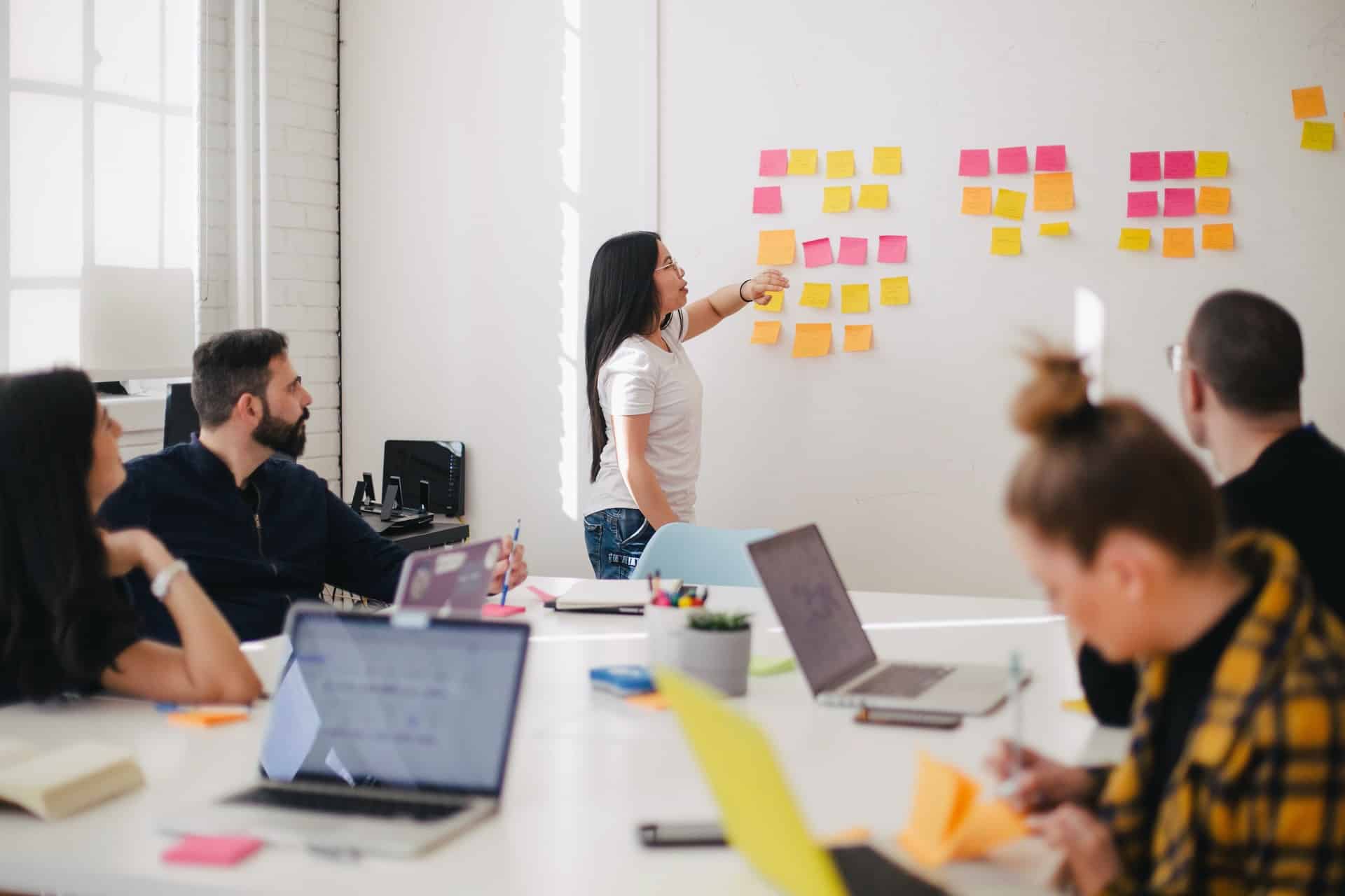 Pessoas em um escritório colocando ideias em post its.
