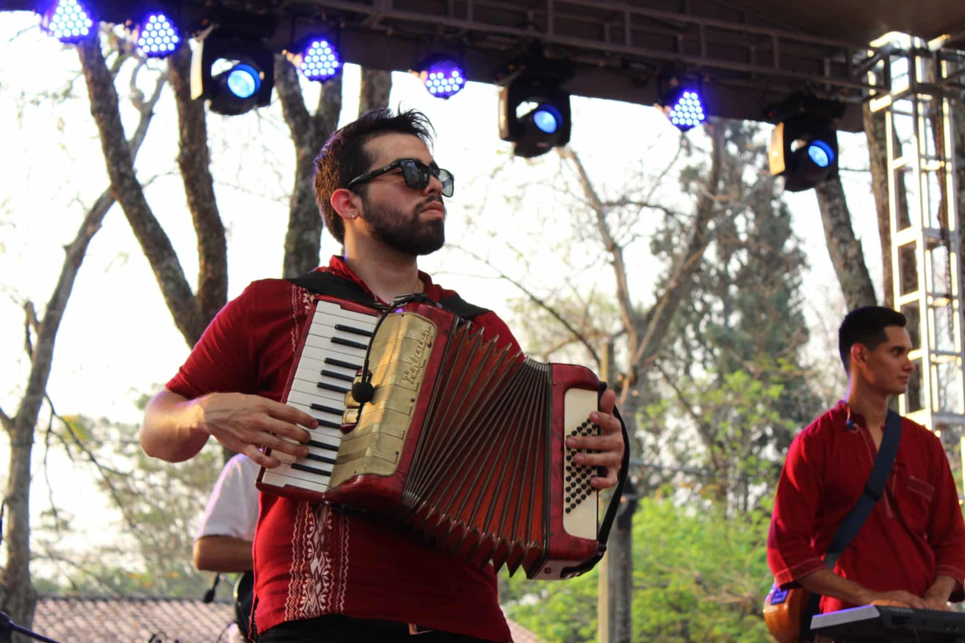 homem de óculos escuros tocando um acordeão