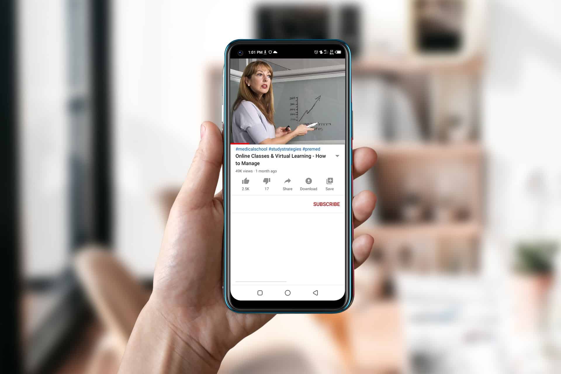 Mão segurando um celular passando uma videoaula.