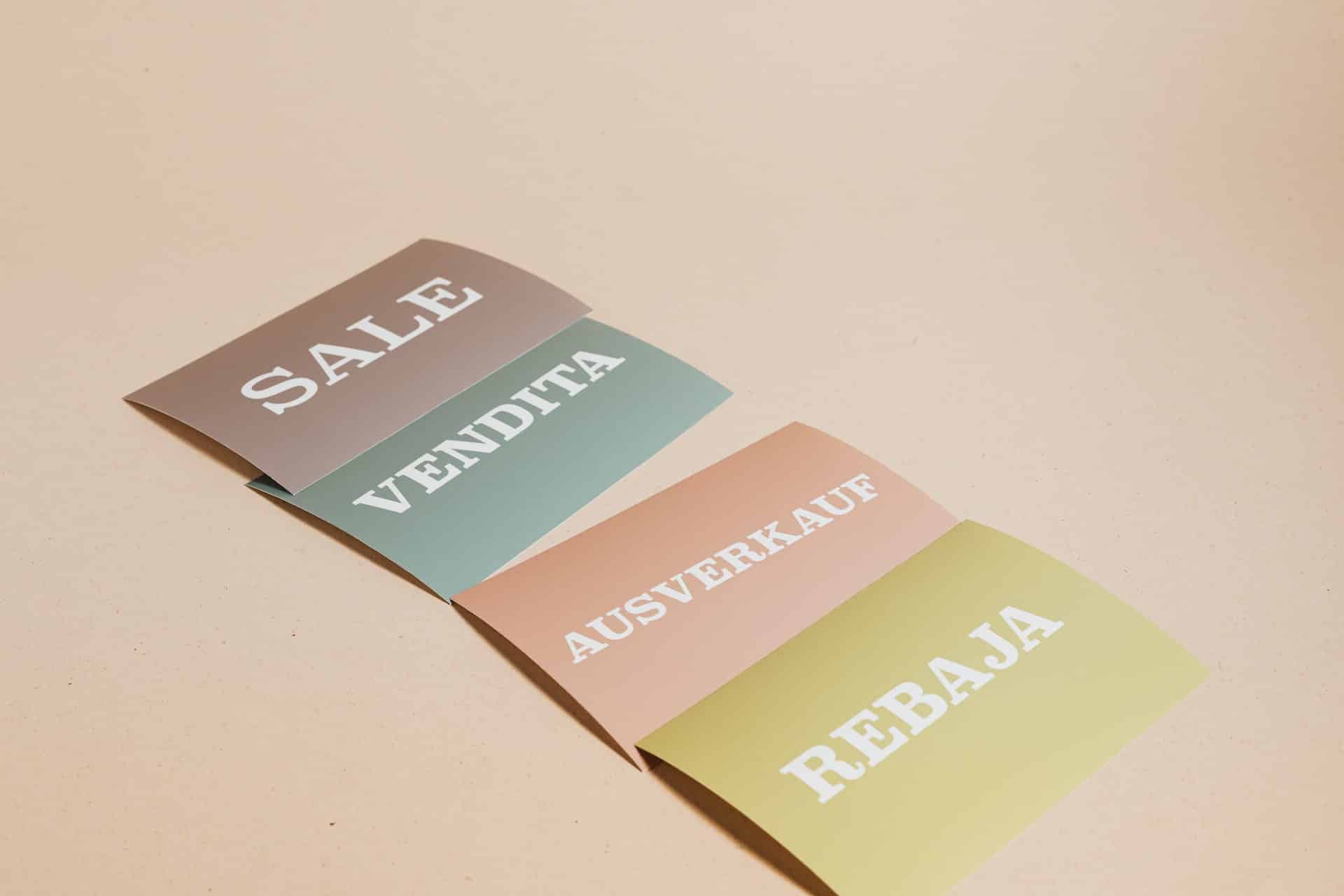 Cada card contém a palavra "promoção" em um idioma diferente. No roxo "sale", no azul "vendita", no vermelho "ausverkauf" e no amarelo "rebaja".