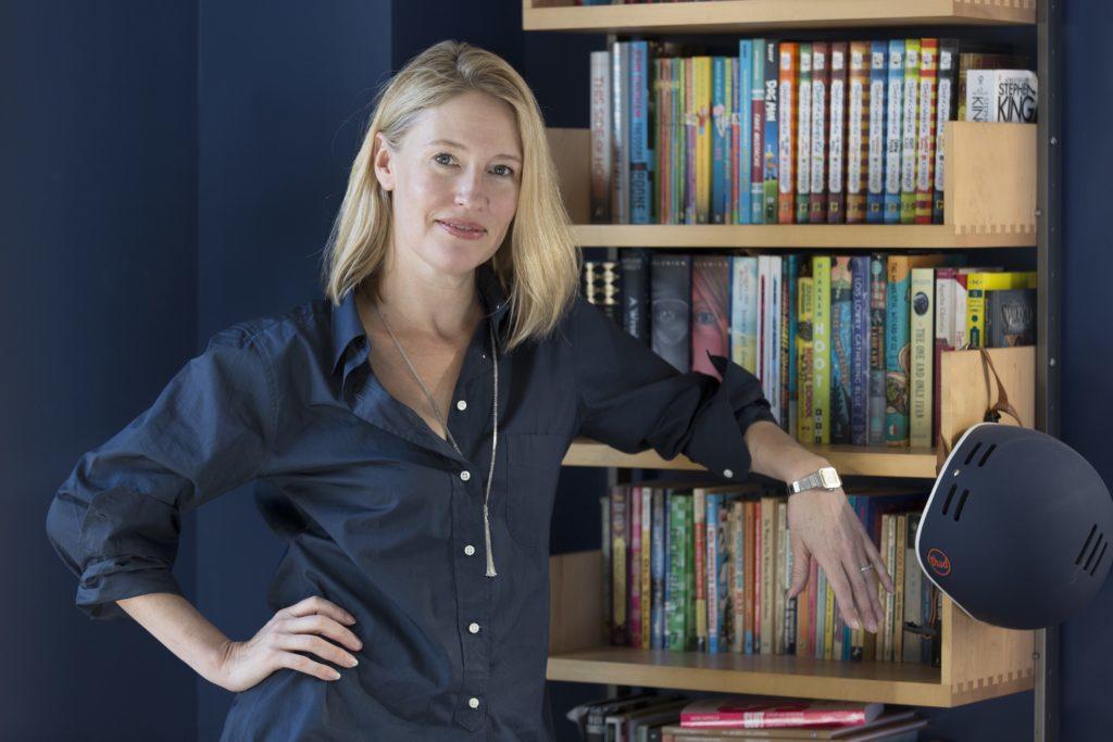 Jennifer Baumgardner de frente para uma estante com livros