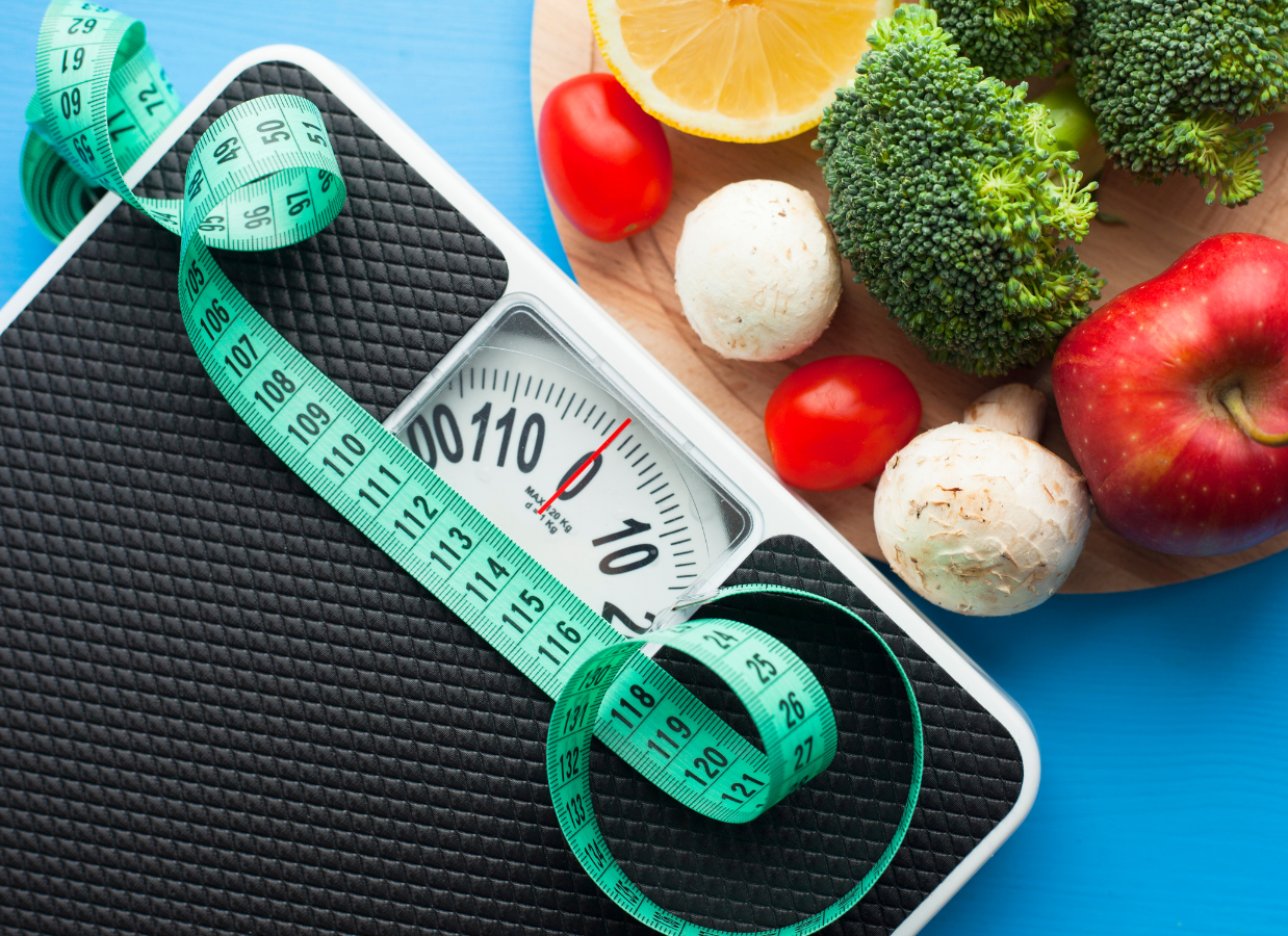 balança e alimentos com uma fita métrica azul