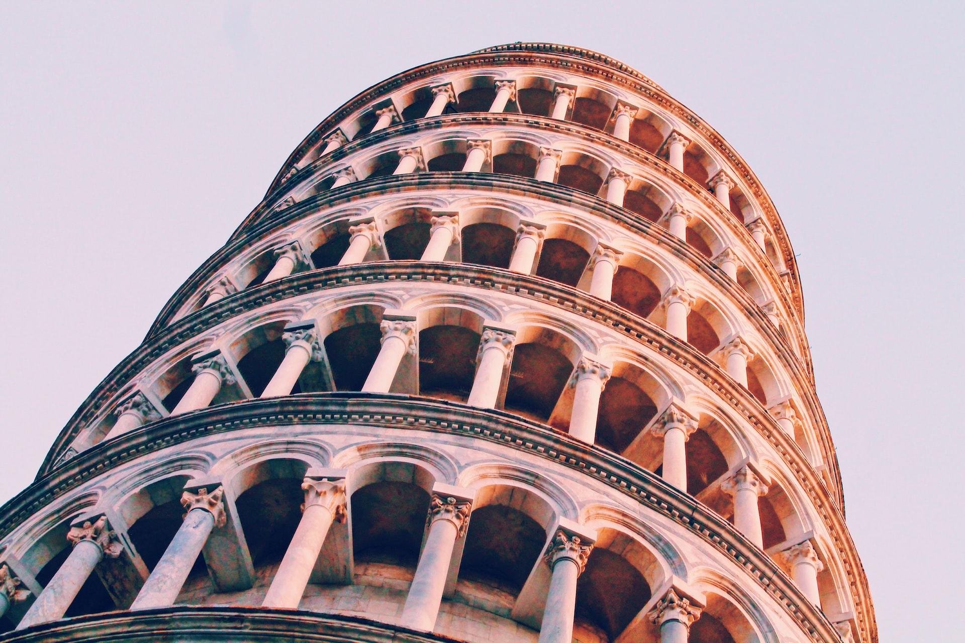 Foto do topo da Torre de Pisa, em um ângulo de baixo para cima.