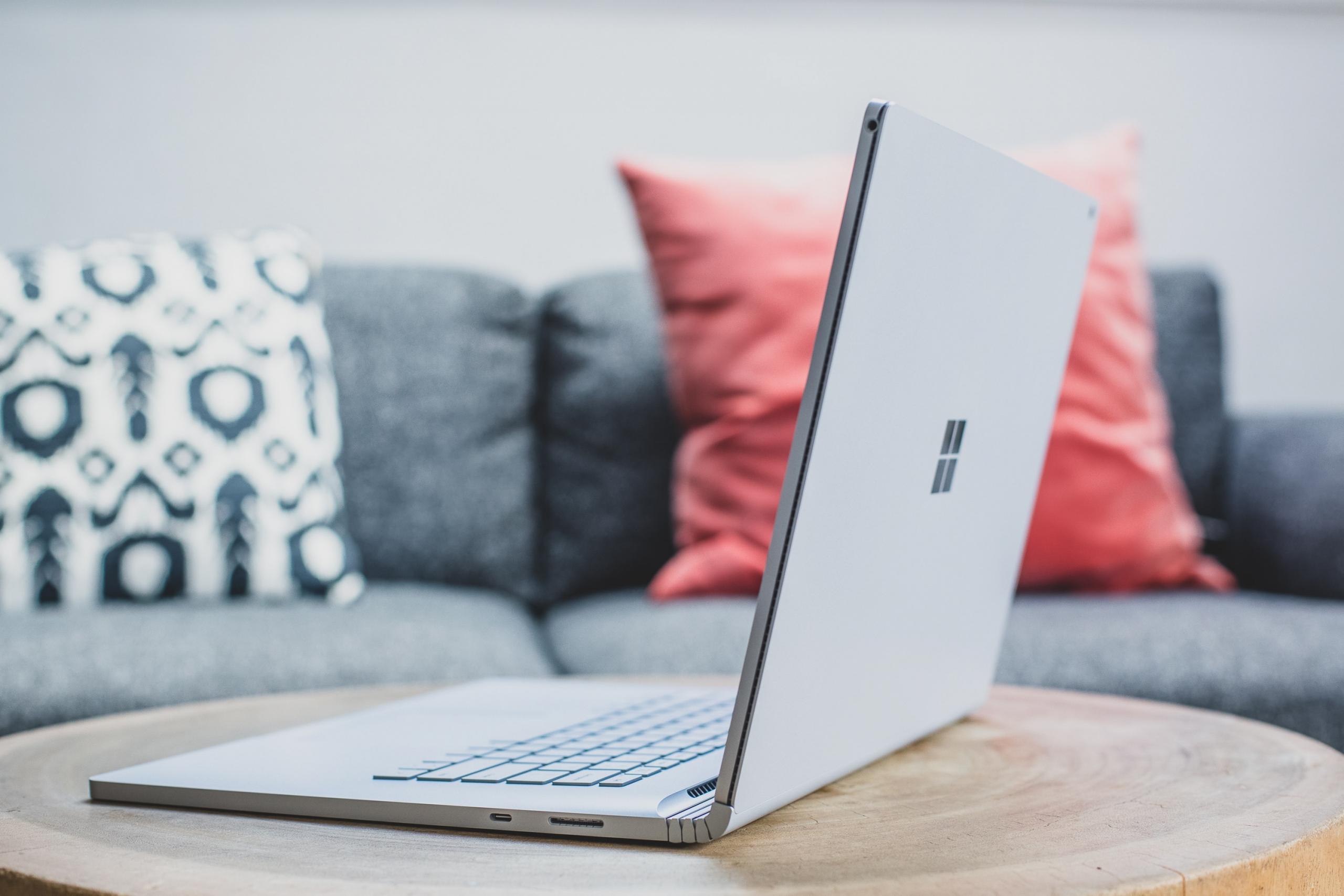 Notebook com sofá de fundo no home office
