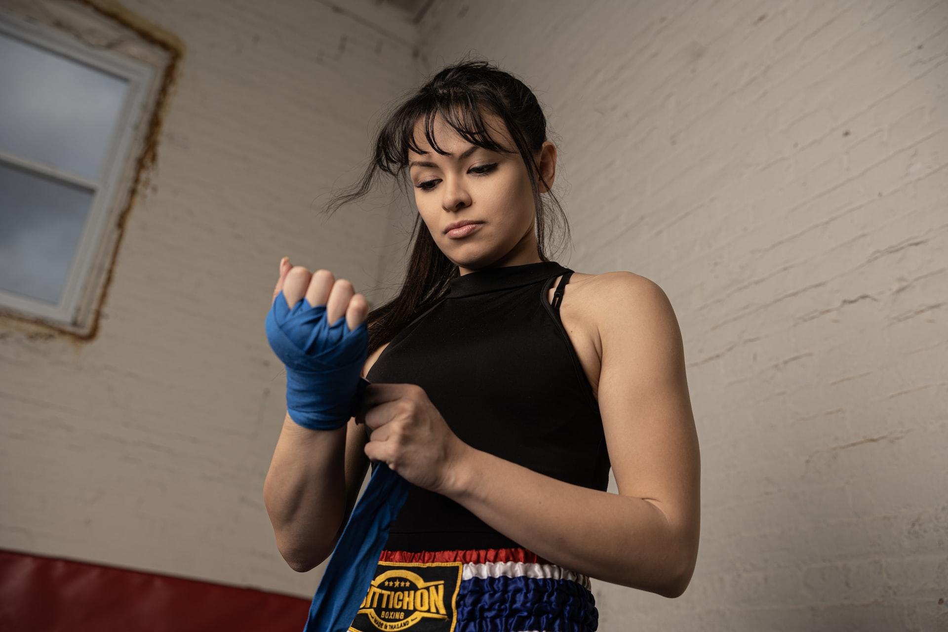 mulher passando luva de boxe na mão