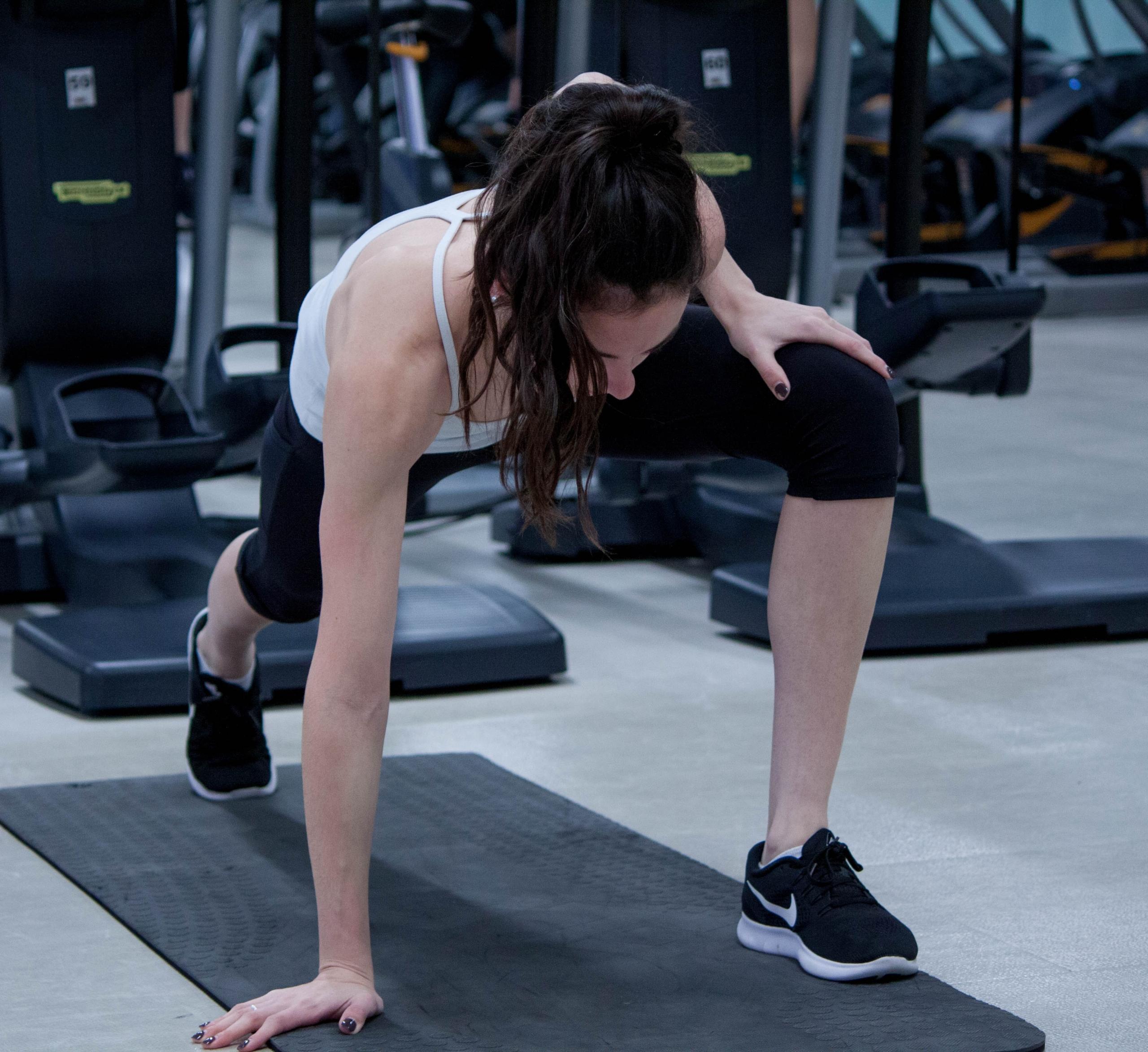 Mulher na academia enquanto pratica pilates