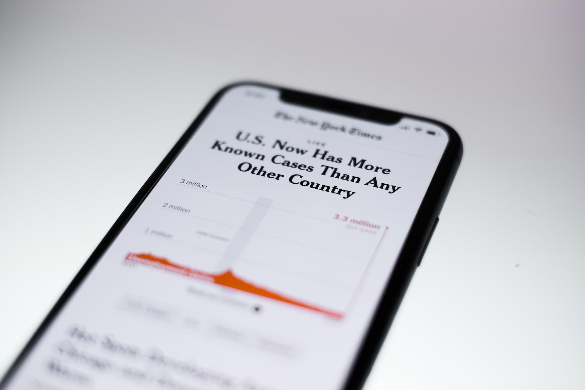Zoom na tela de um celular com uma notícia escrita em inglês.