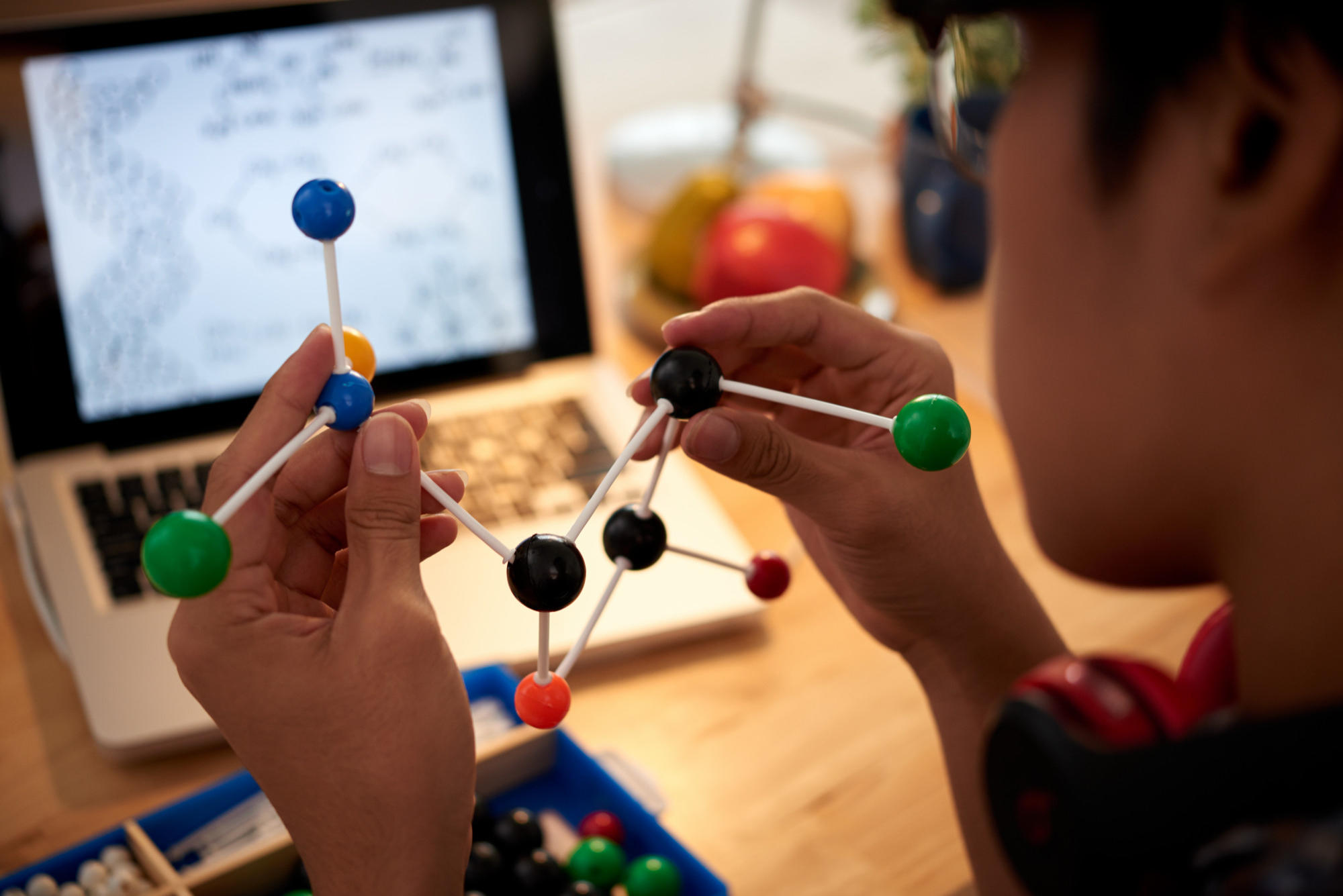 Menino estudando química online.