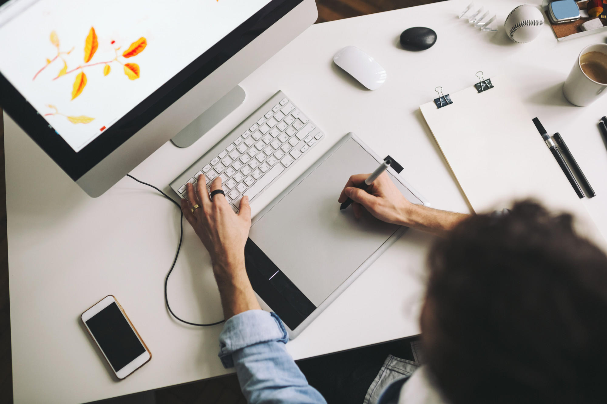 Pessoa usando a mesa digitalizadora para Photoshop.