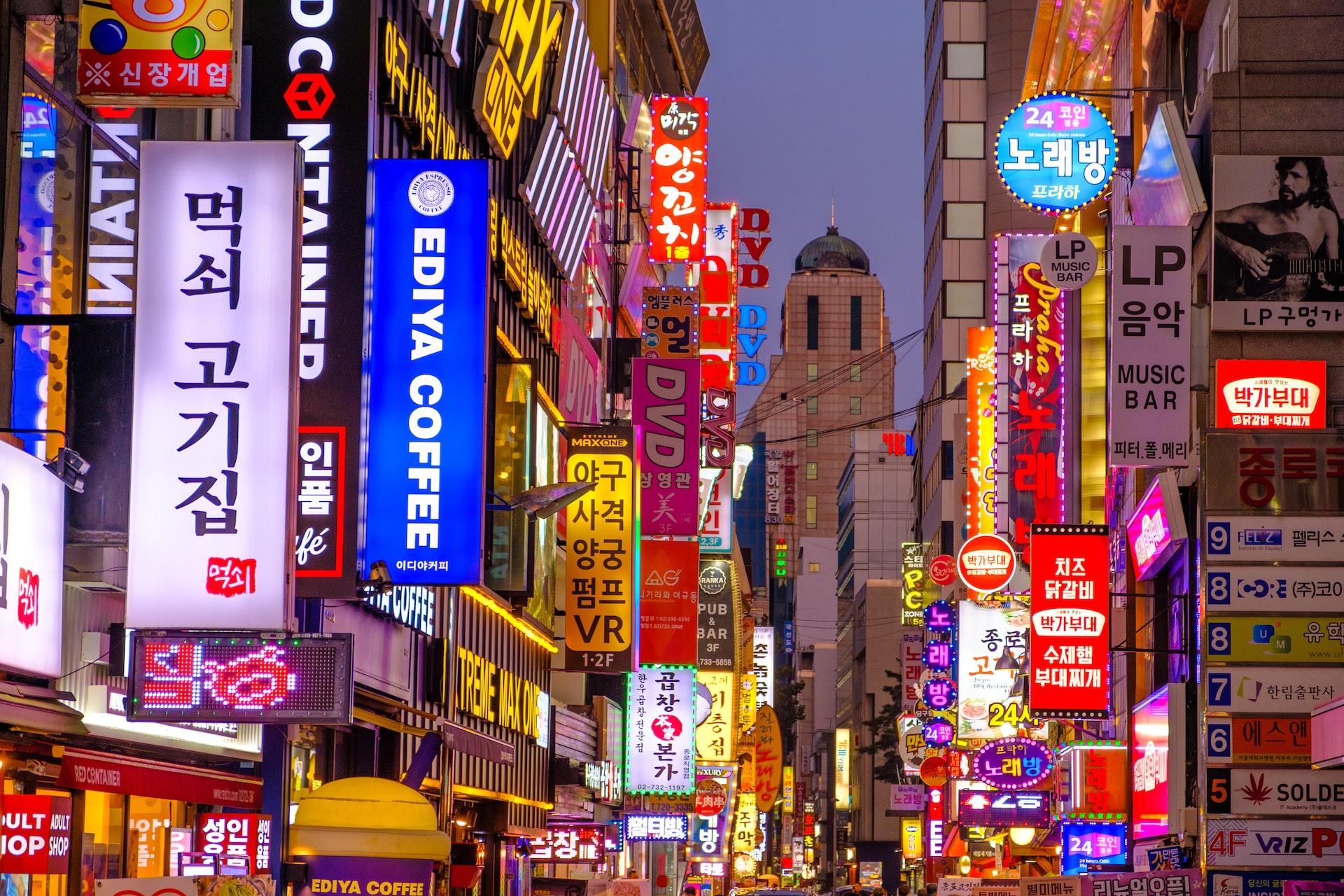 Várias placas luminosas em uma rua de Seul, escritos em coreano