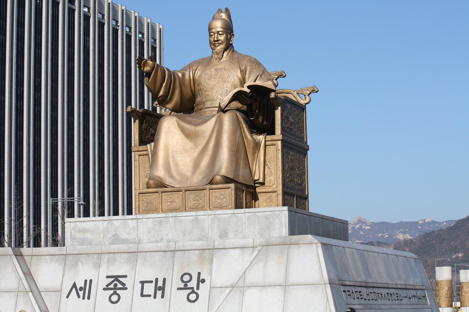 Estátua do rei Sejong, o Grande em bronze, sobre uma base com letras coreanas.