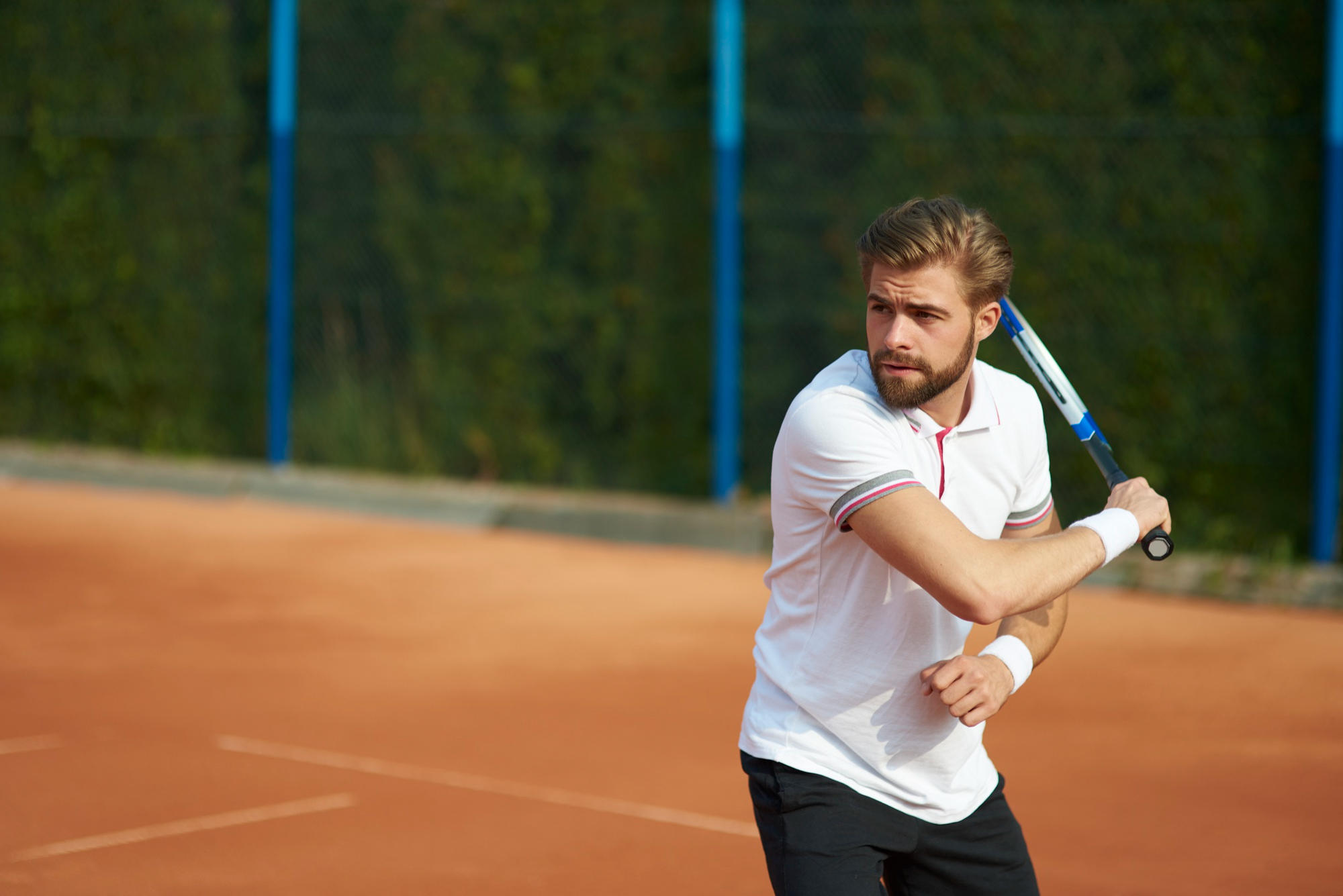 Atleta praticando tênis na quadra.