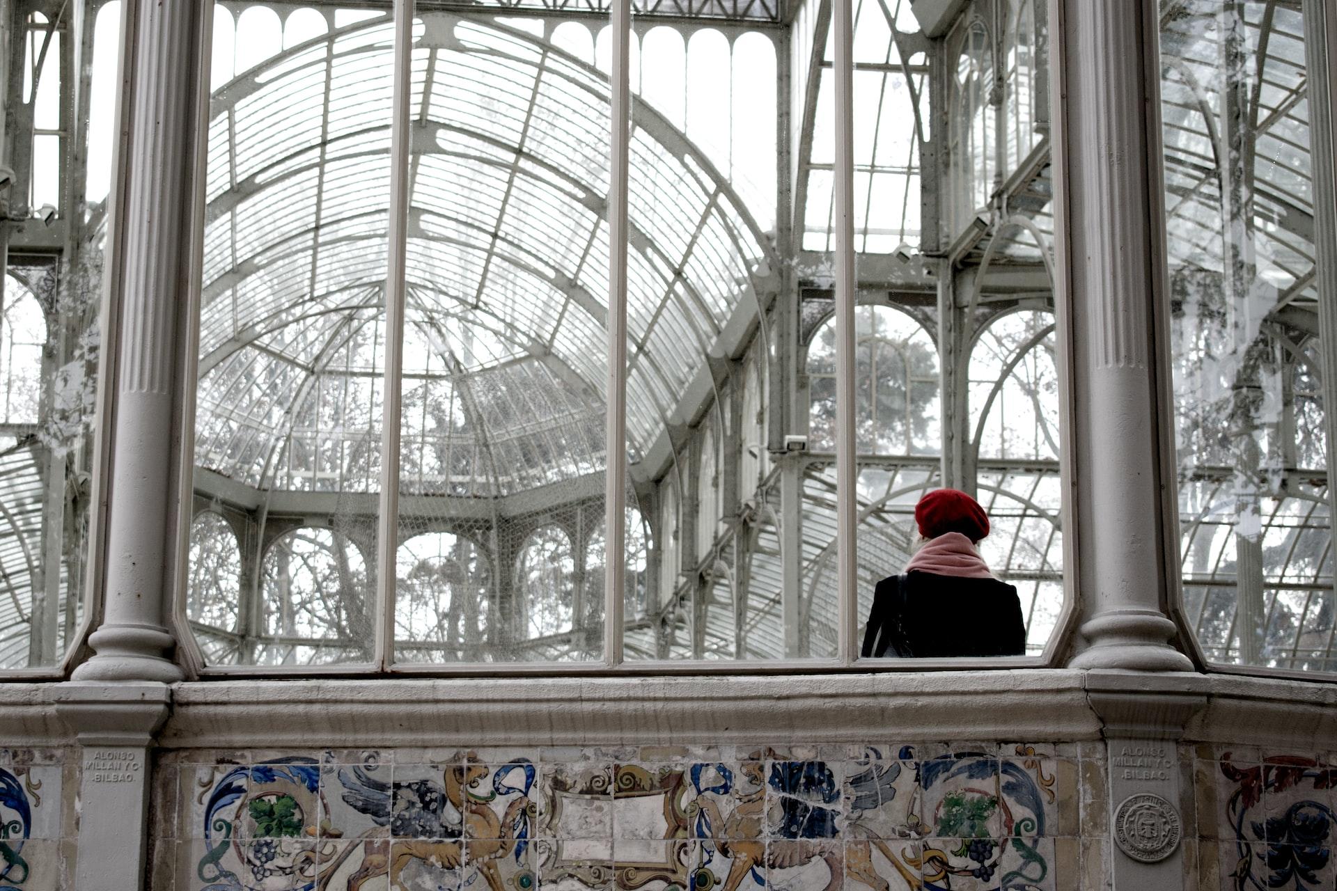 Palácio de Cristal, de uma perspectiva que mostra a sua cúpula, e uma pessoa apreciando a paisagem.