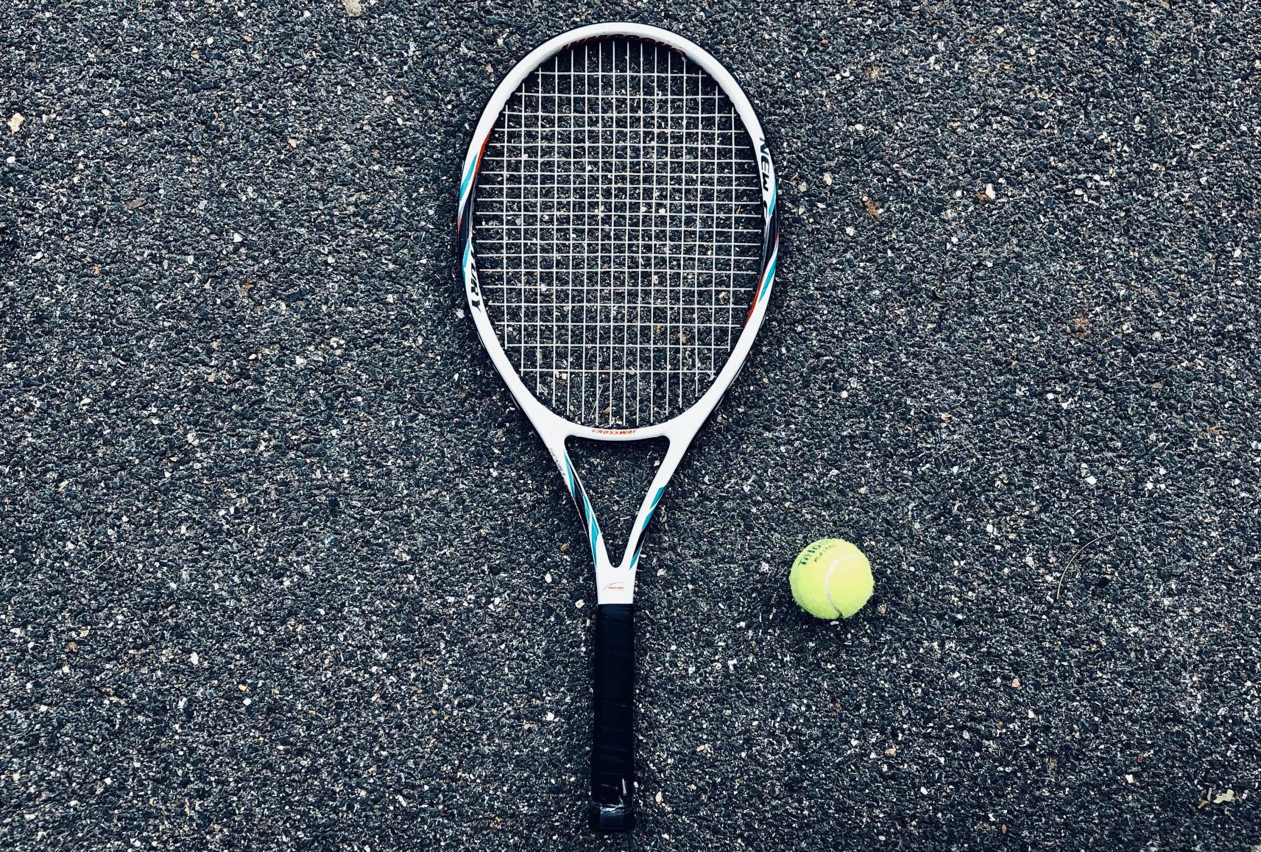 Raquete e bola amarela de tenis profissional no chão da quadra do esporte. 