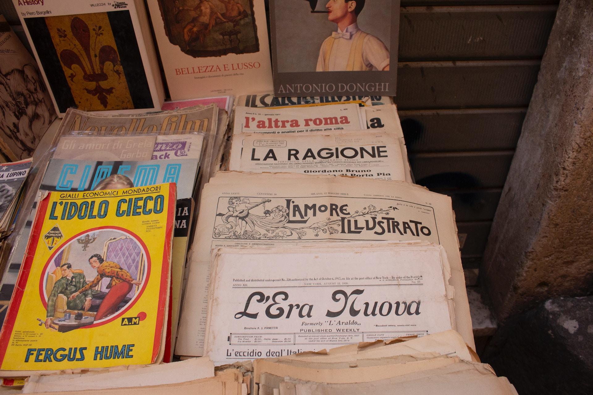 Livros e jornais italianos em cima da mesa.
