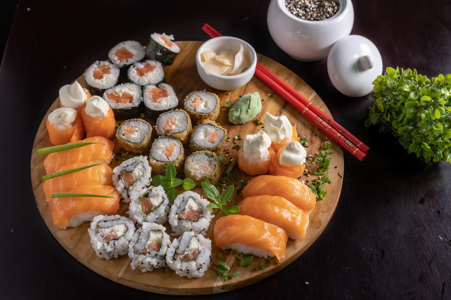Tábua com diversos sushis e itens da culinária japonesa.