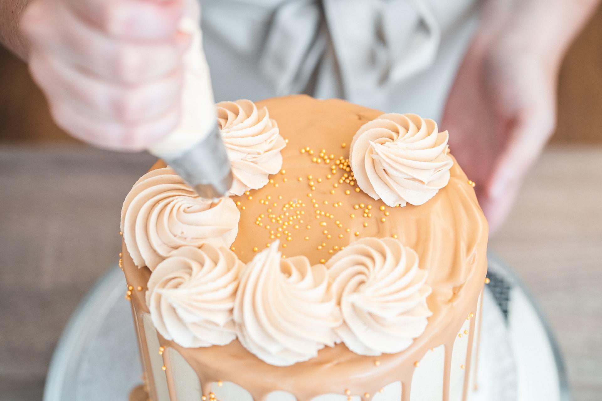 pessoa confeitando um bolo laranja