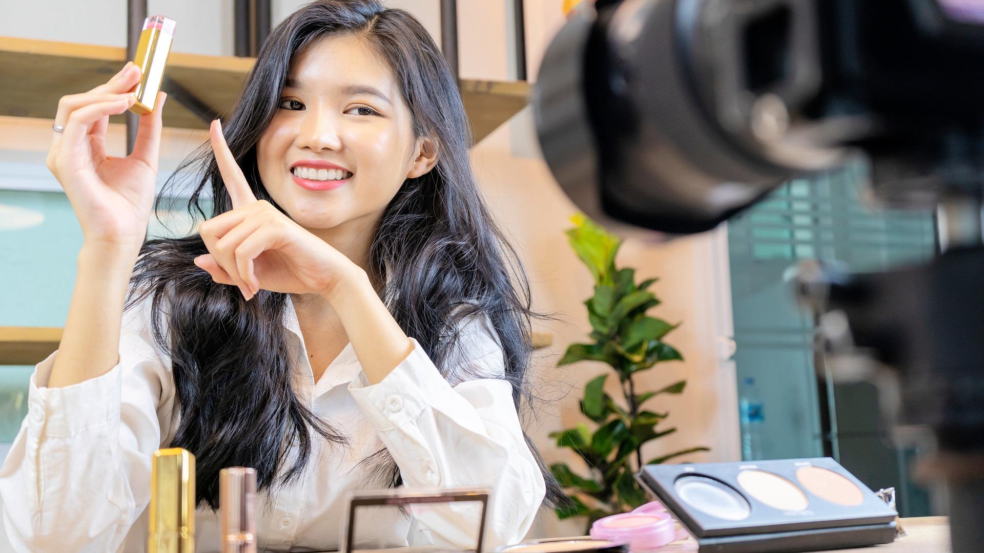 Mulher apresentando produtos de maquiagem em um vídeo.