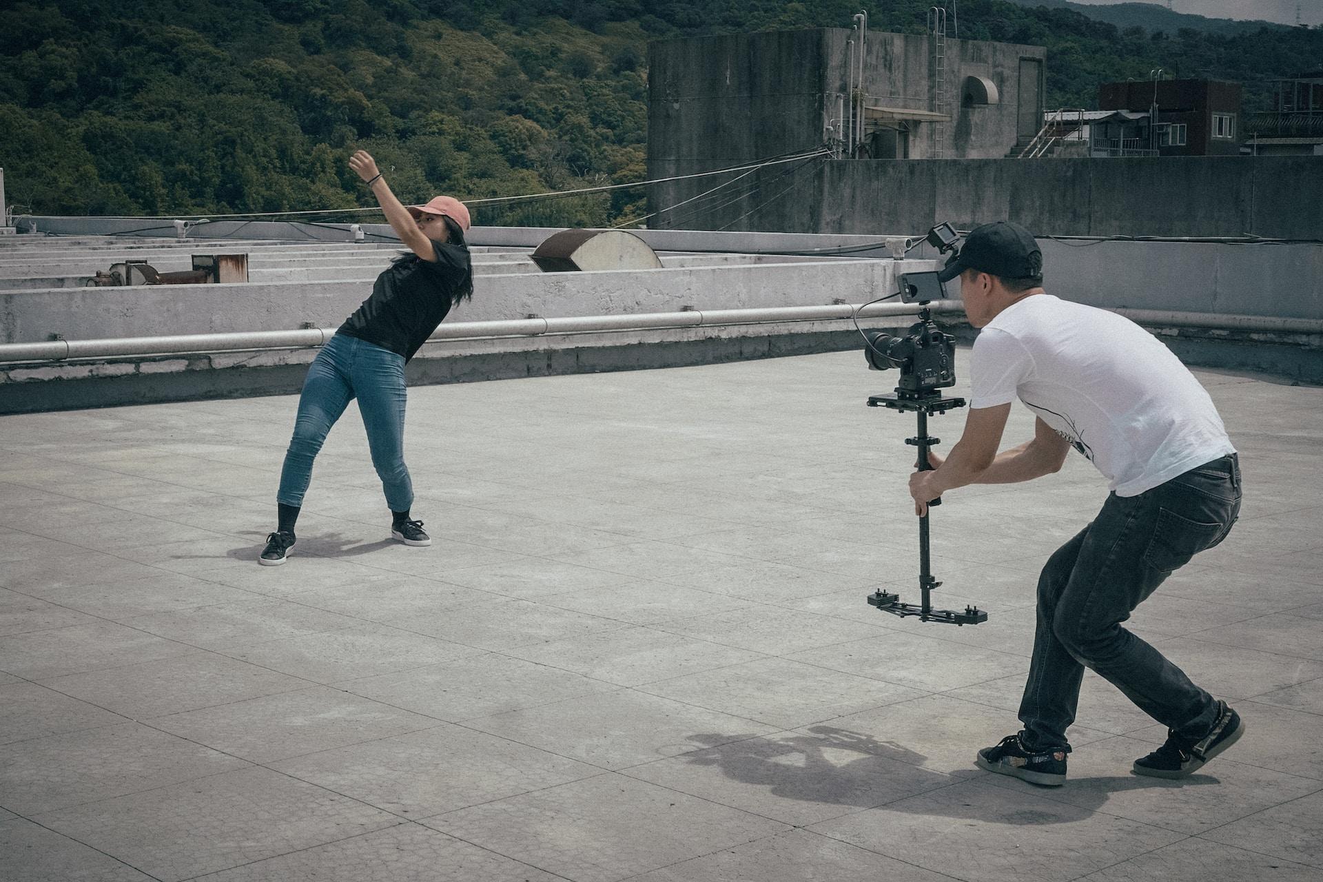Homem filmando uma mulher dançando.