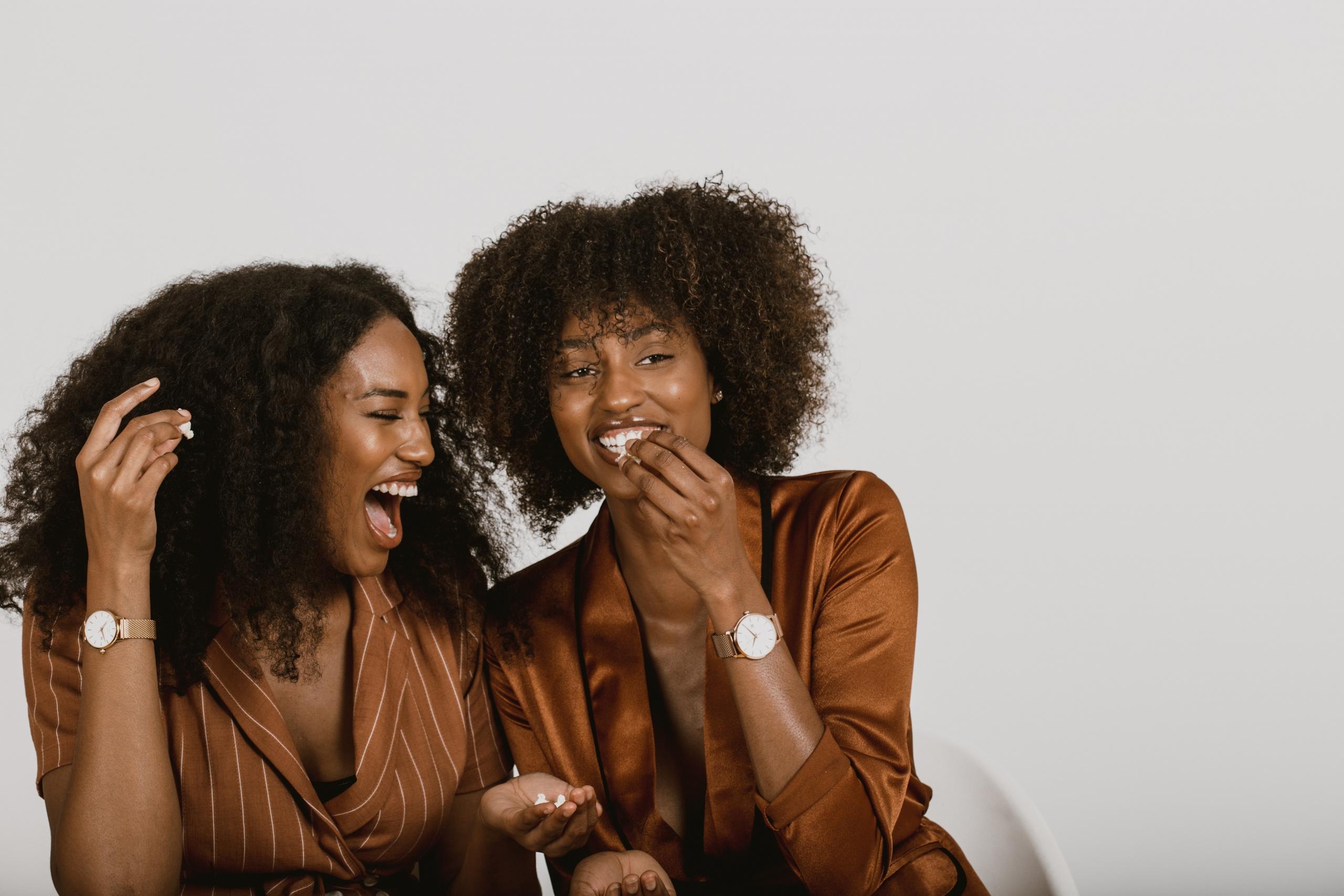 Duas mulheres negras conversando com fundo claro