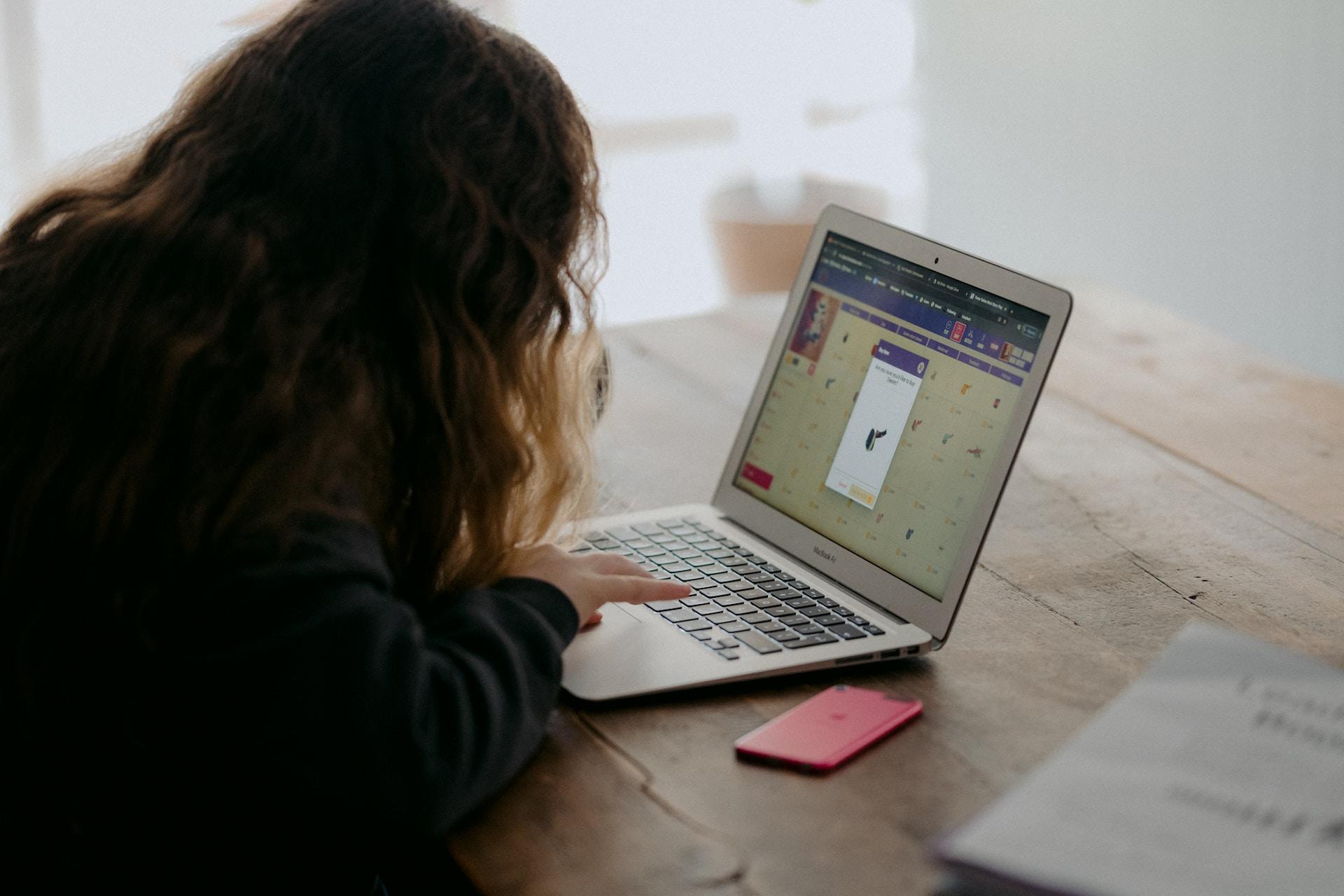 menina olhando para um aplicativo ou jogo no computador