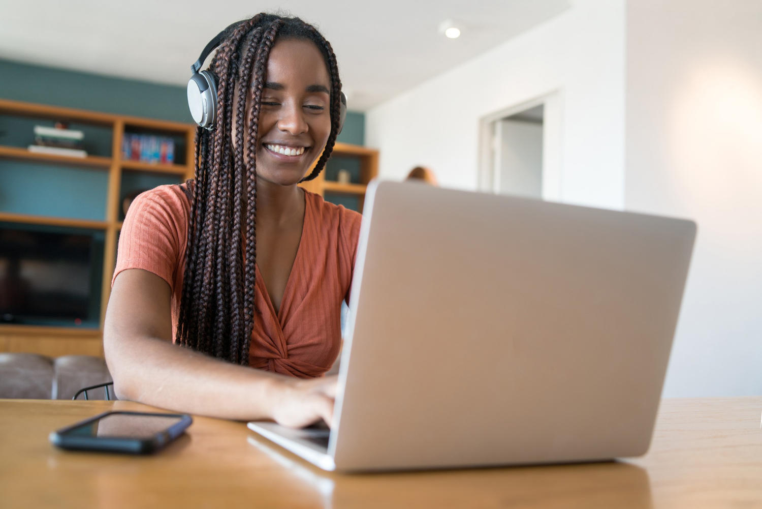 Mulher assistindo à aula de tranças online.