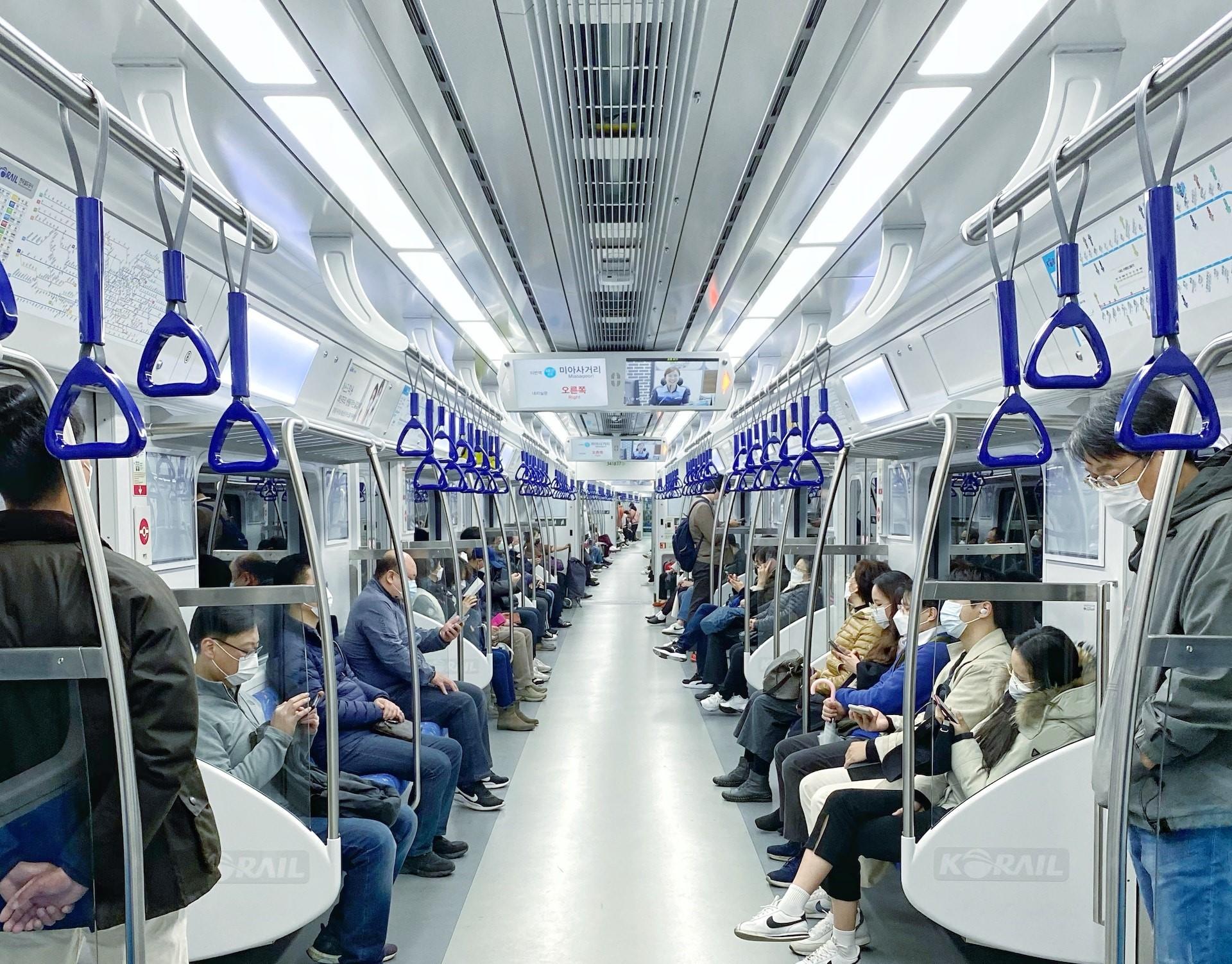 Foto de pessoas sentadas no metrô em Seul