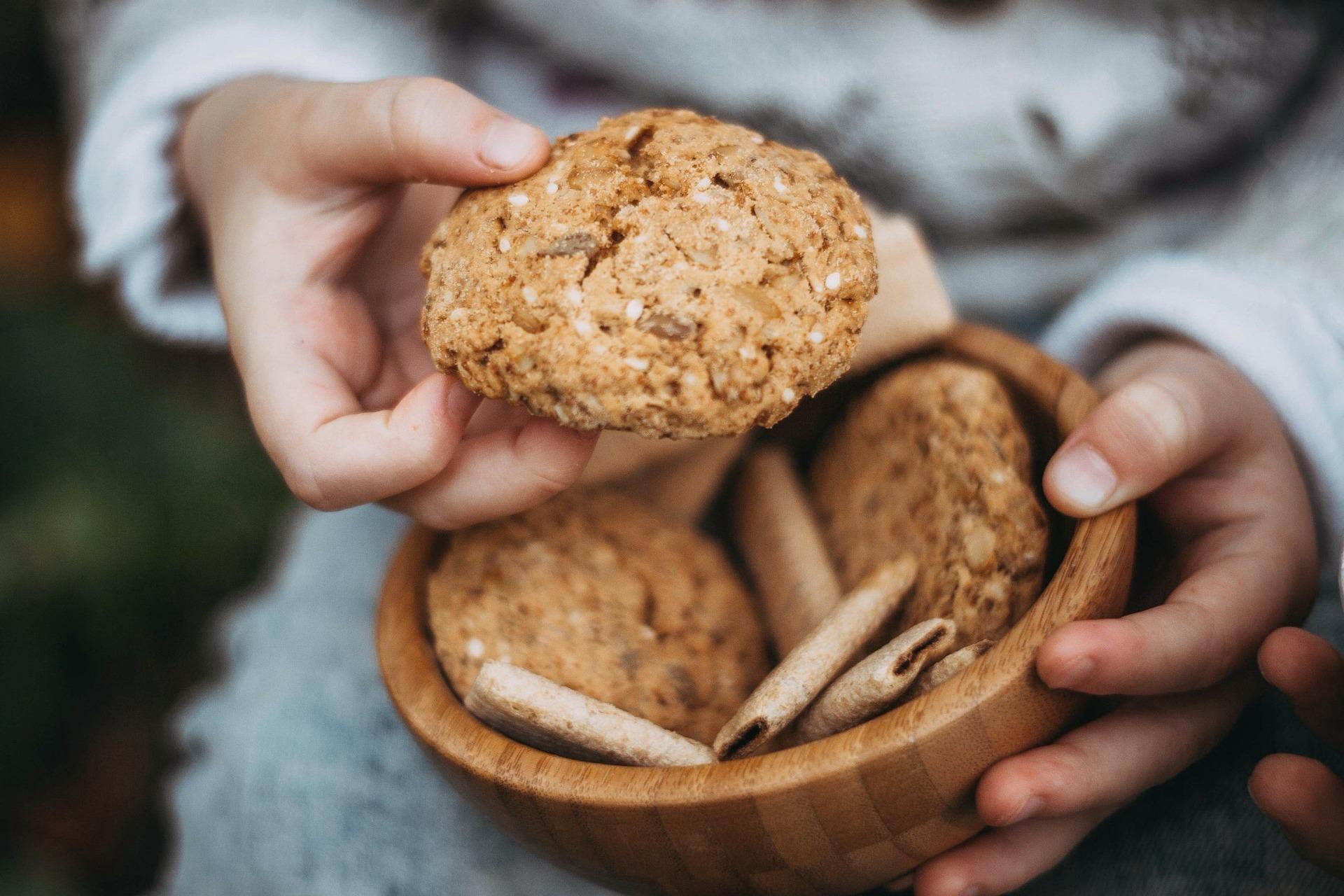 Mãos segurando uma vasilha com biscoitos.