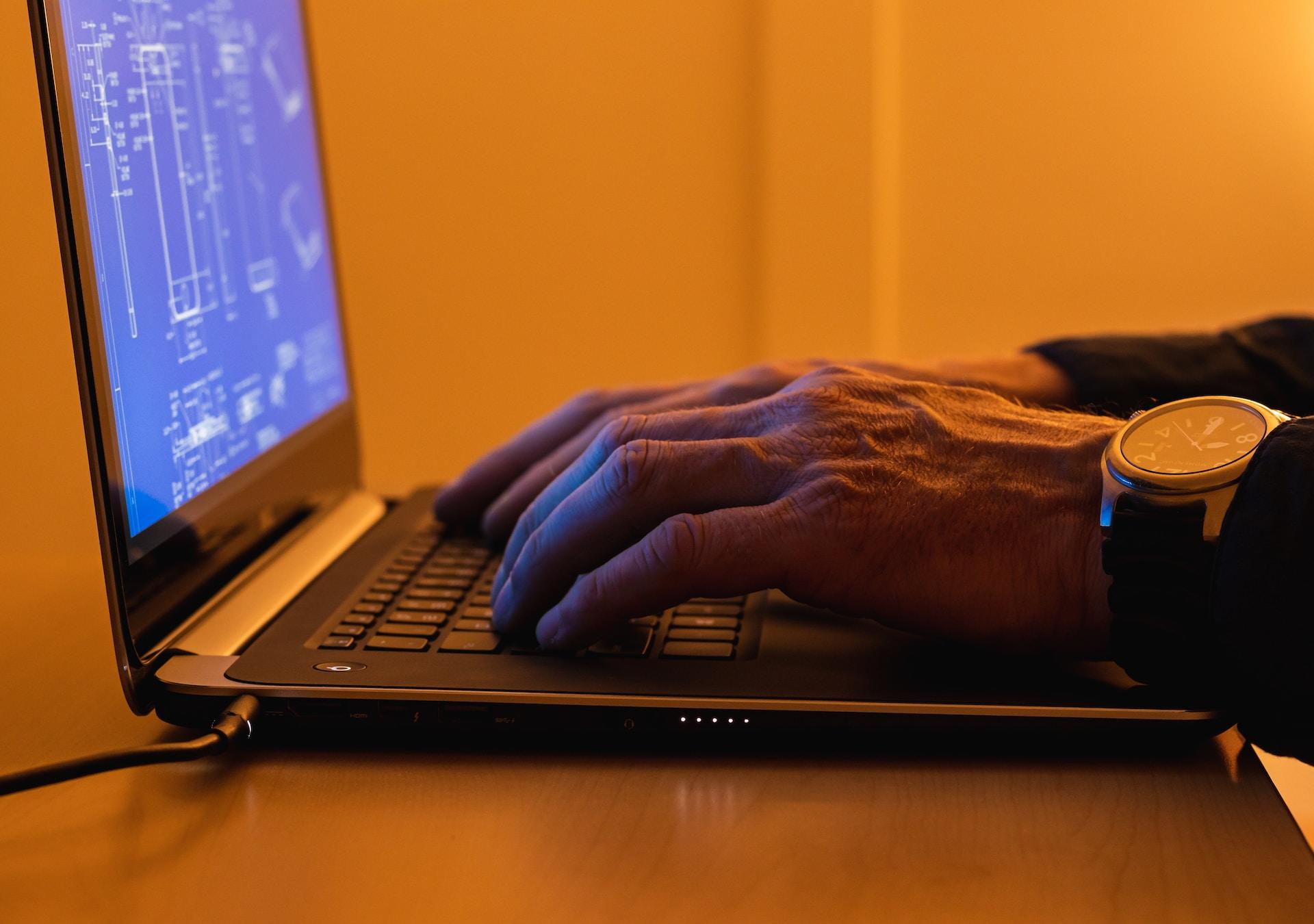 Mão em cima de teclado com programa de design aberto