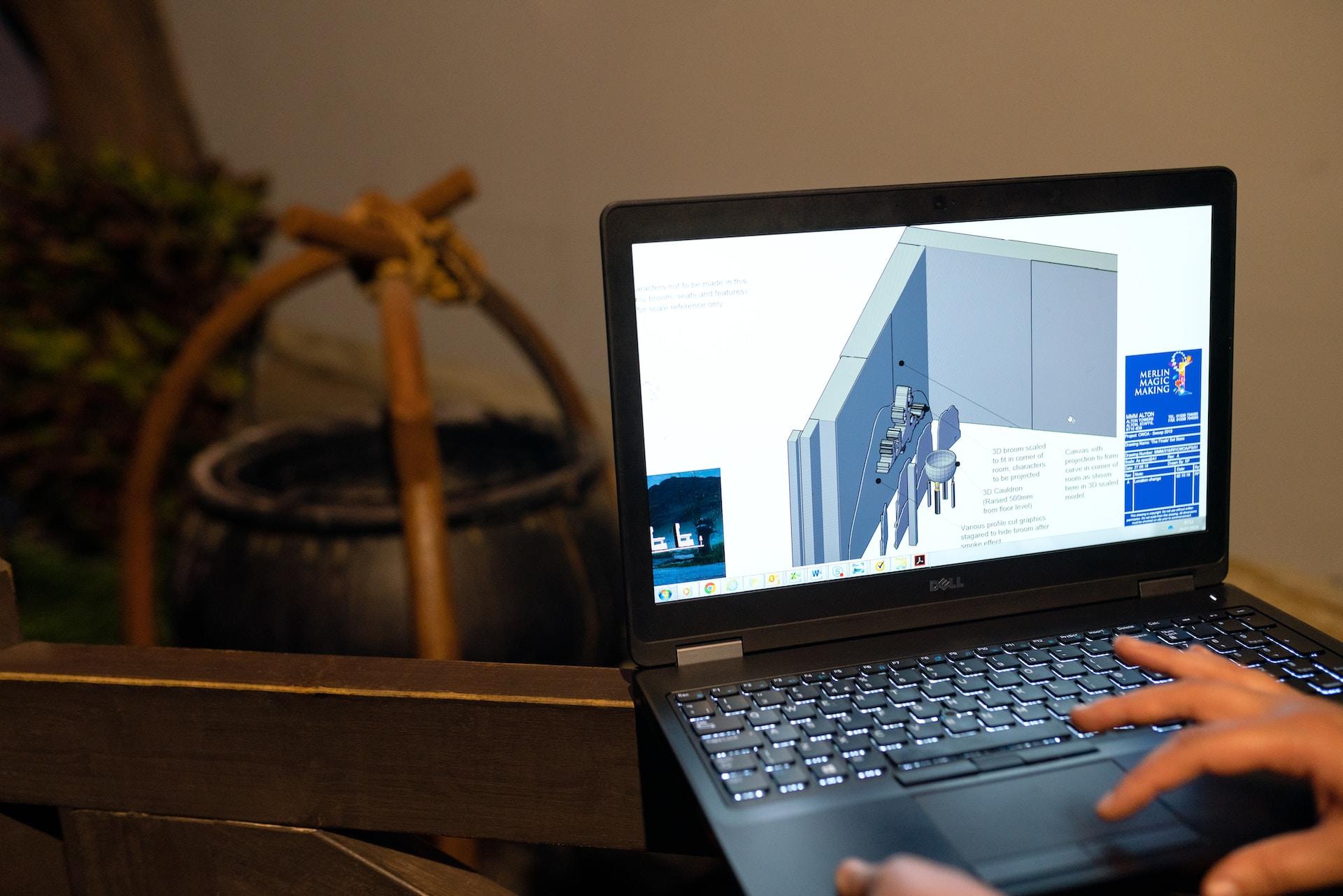 Tela de computador com mão aparecendo enquanto profissional mexe em programa de engenharia