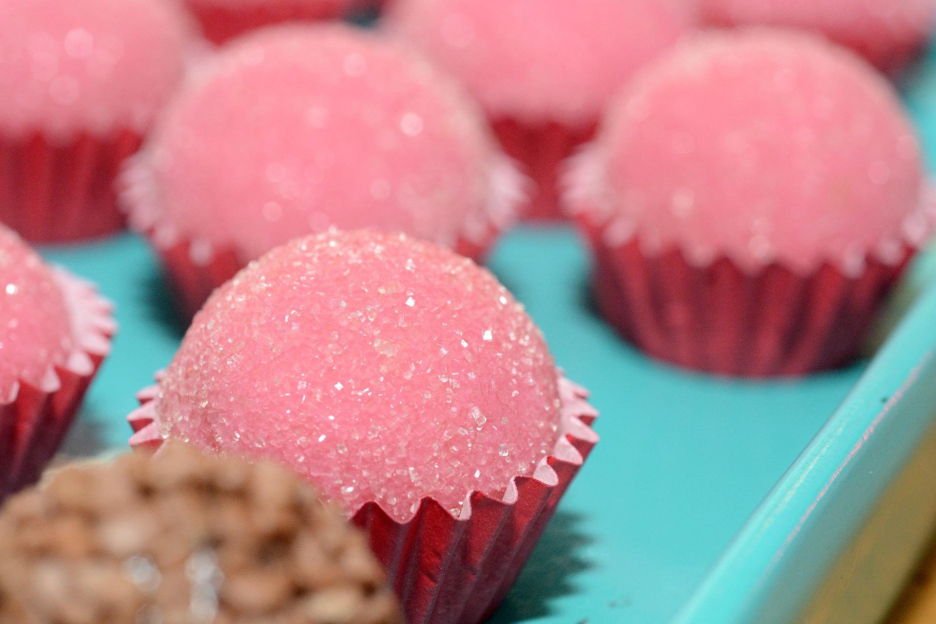Brigadeiros de morango em forminhas vermelhas.