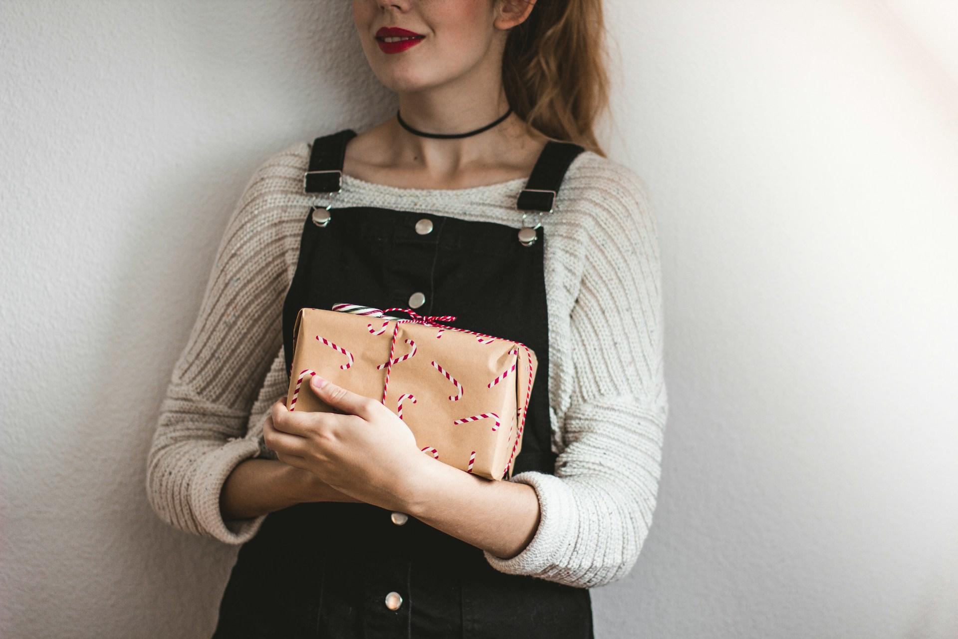 moça segurando um presente de natal nos braços