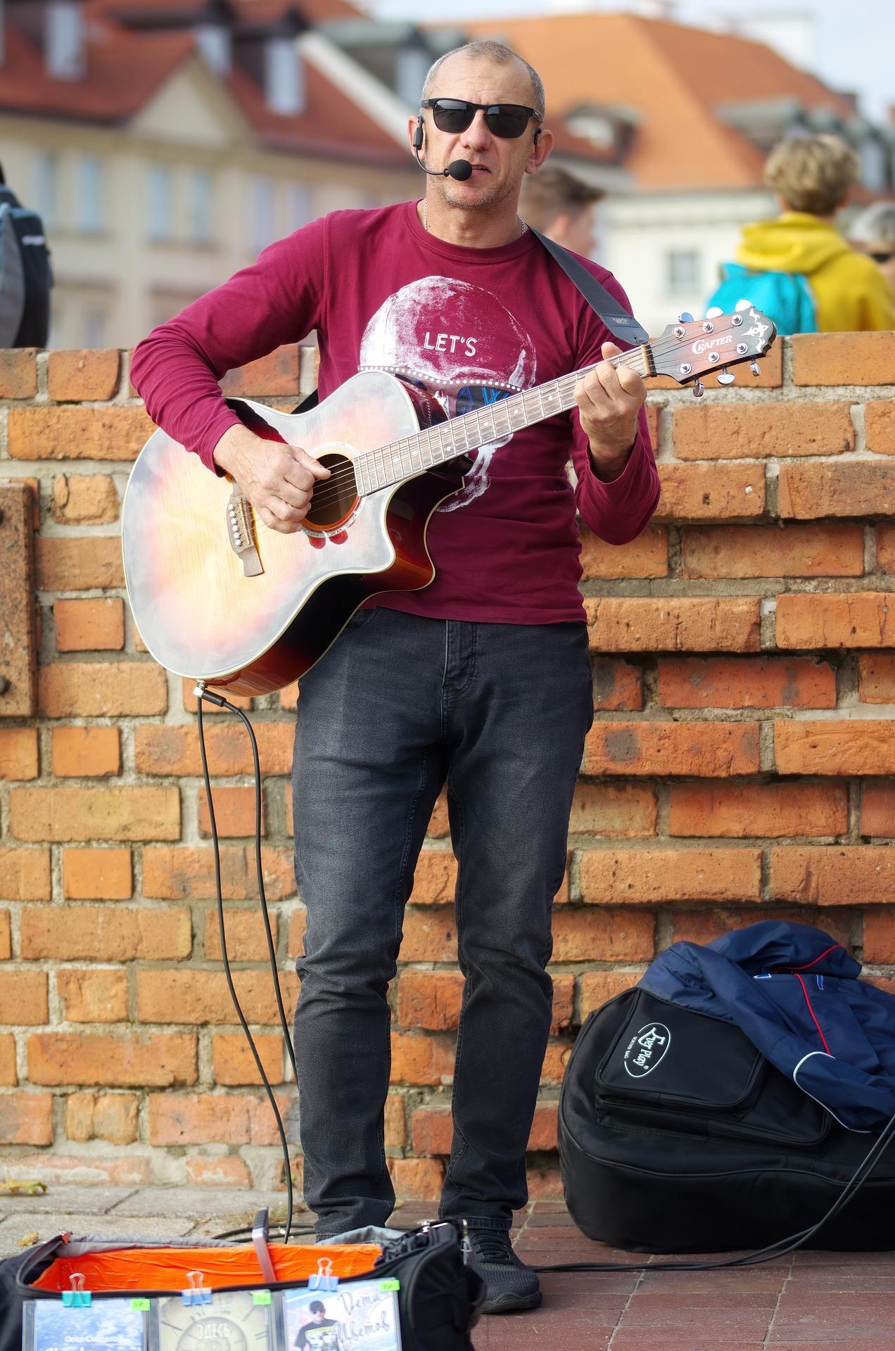 Artista de rua tocando violão e cantando.