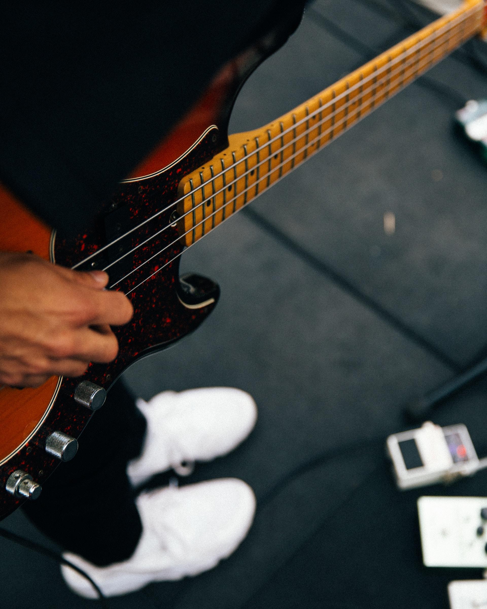 Foto de uma pessoa tocando o baixo em um palco.