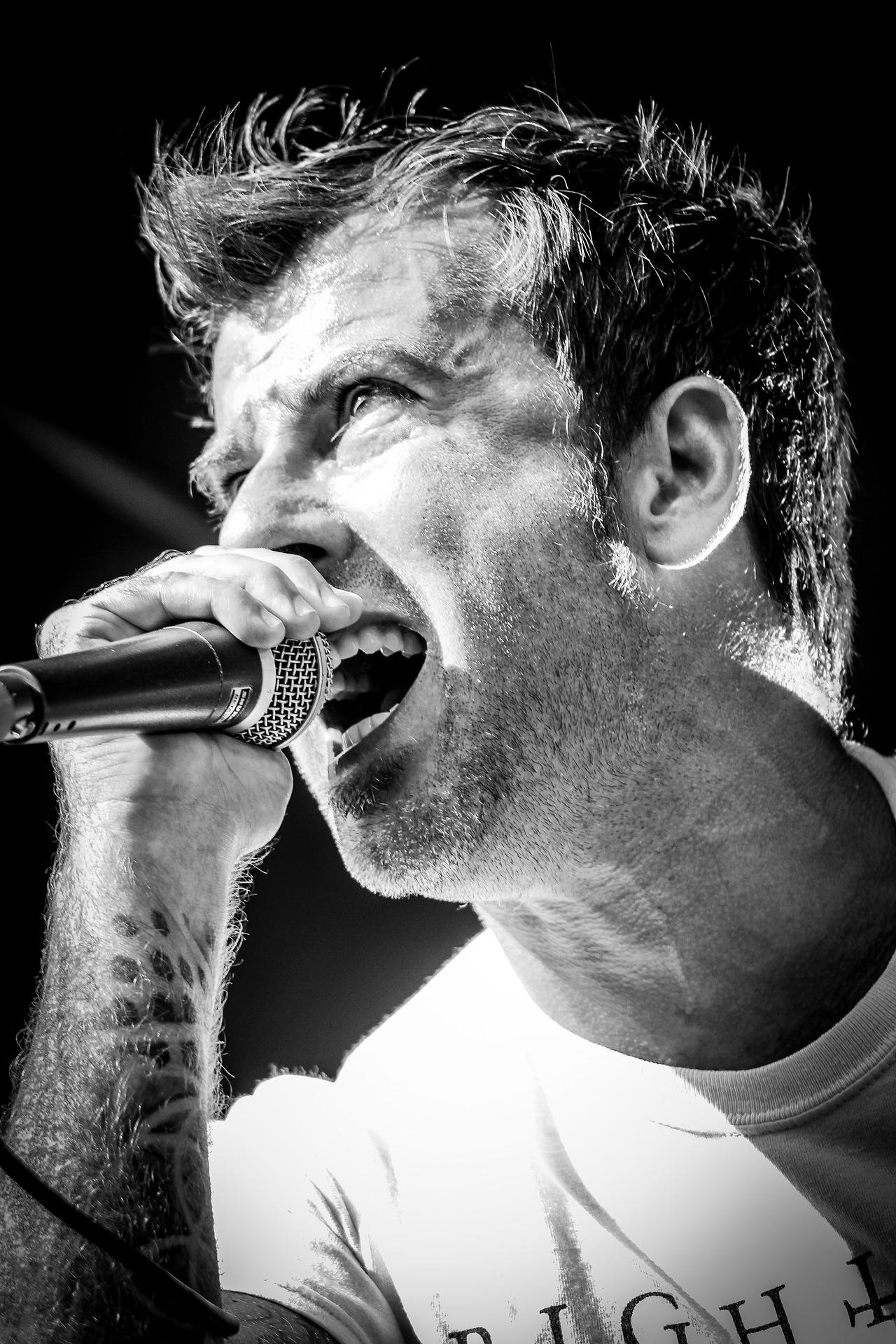 Homem grisalho cantando.