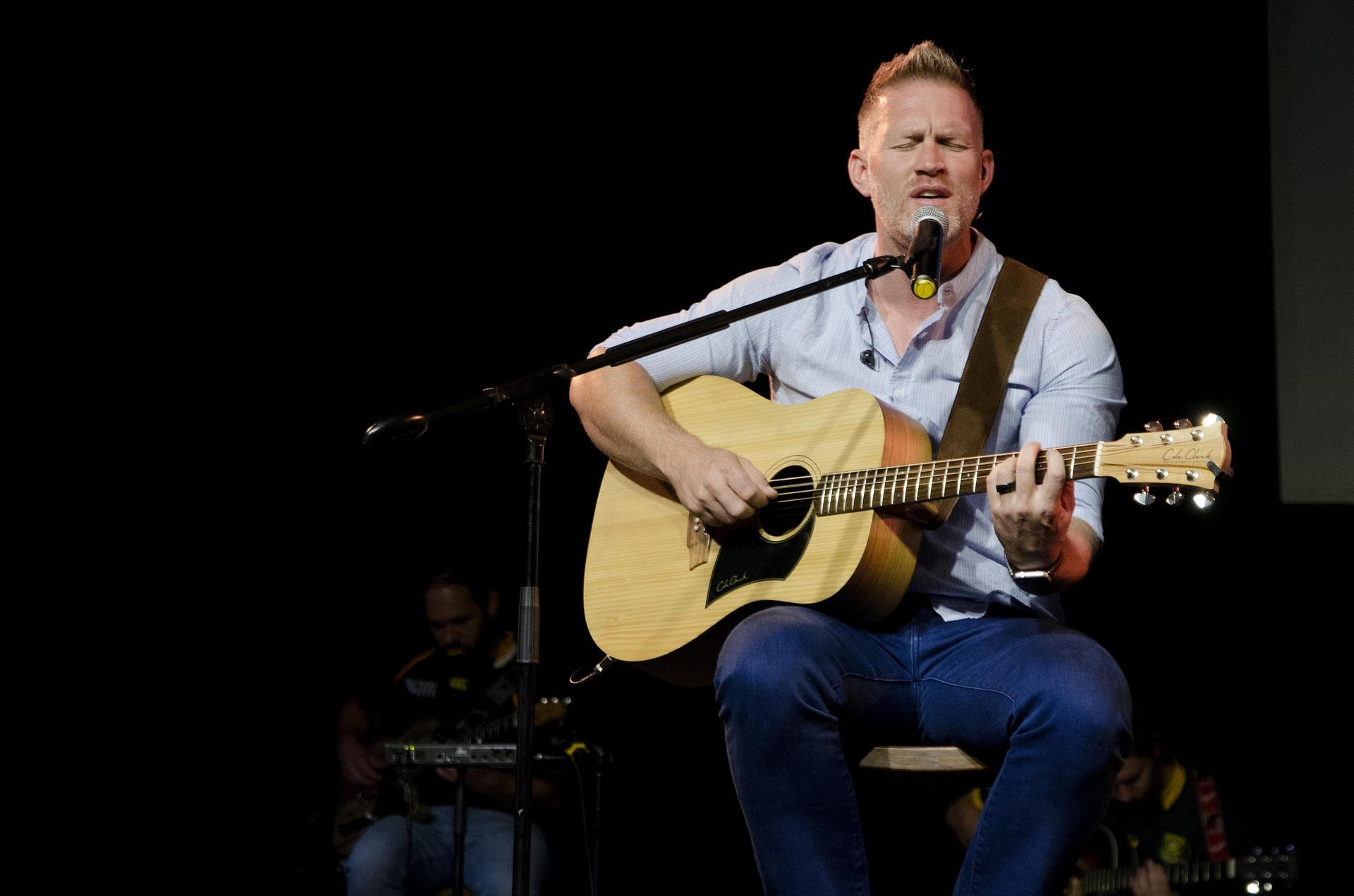 Homem cantando e tocando violão