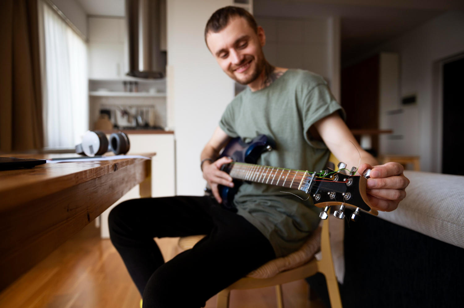 Homem tocando baixo na sala de casa.