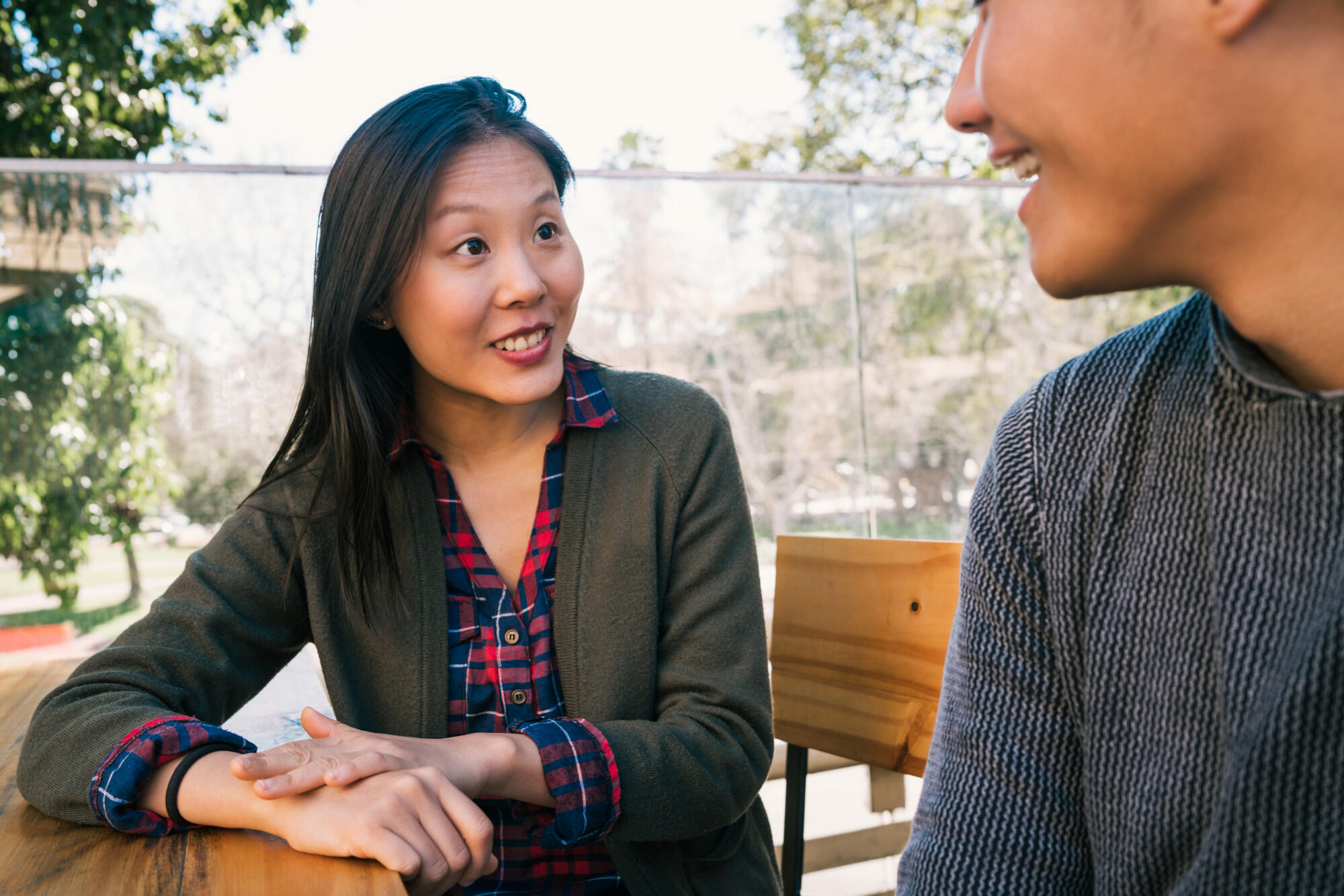 Duas pessoas conversado, sentadas, e rindo.